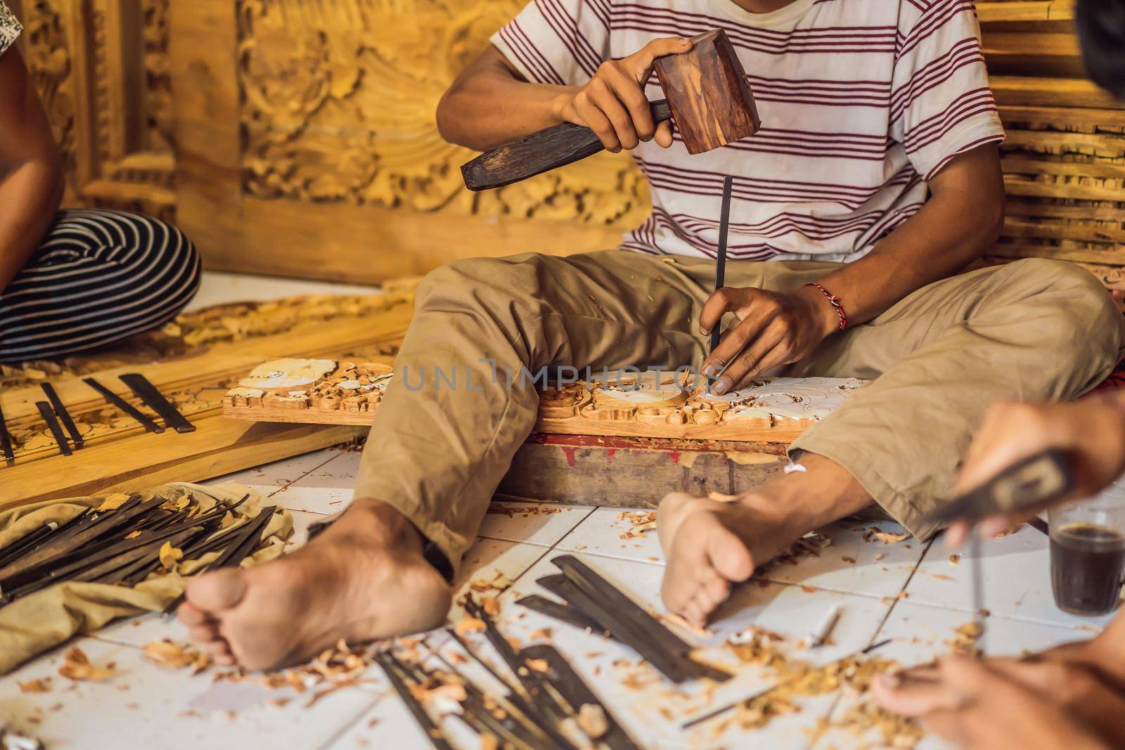 Master wood-carver made using a special knife wooden national dish - a ladle with a patterned handle. A fragment of a close-up of his hands.