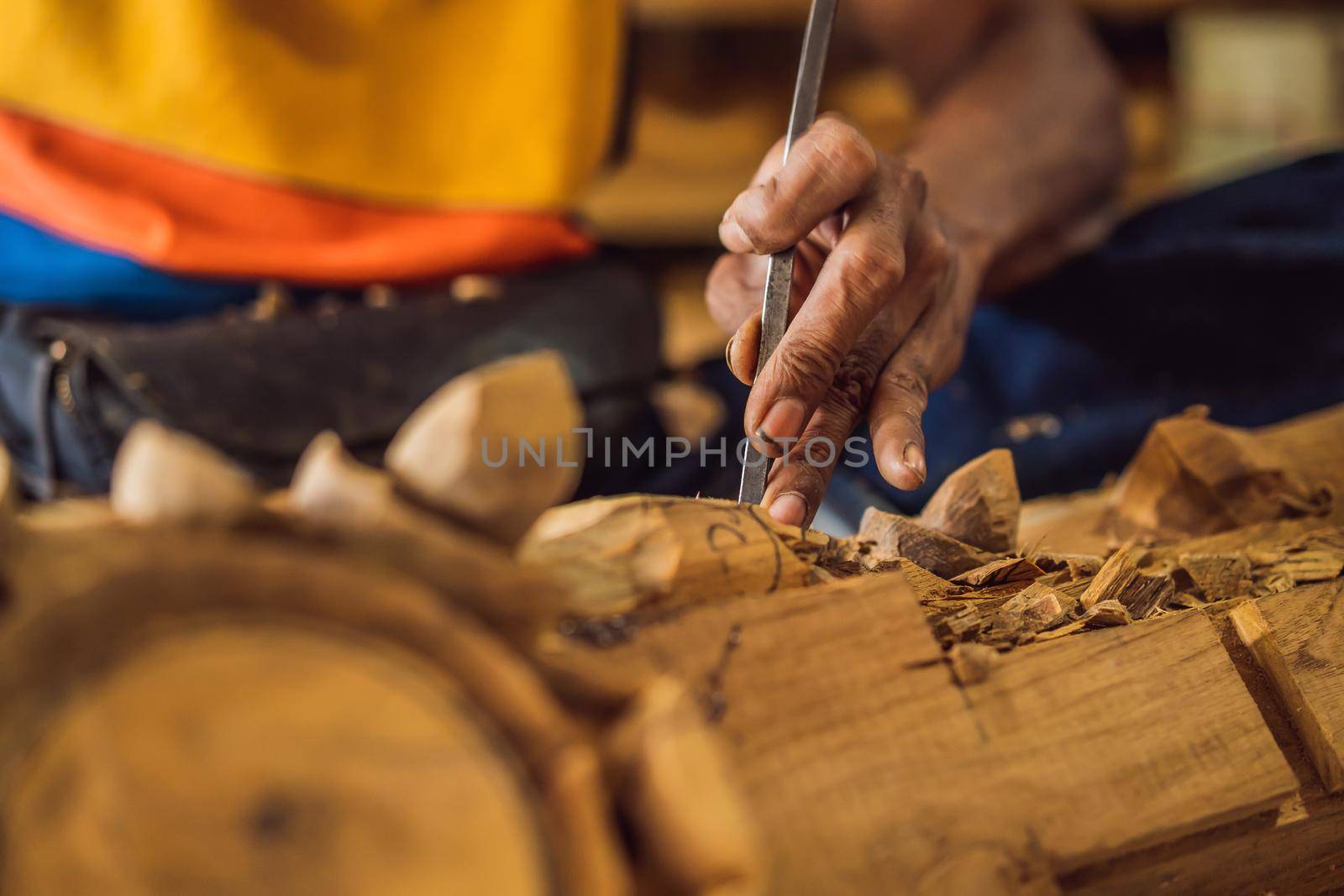 Master wood-carver made using a special knife wooden national dish - a ladle with a patterned handle. A fragment of a close-up of his hands.