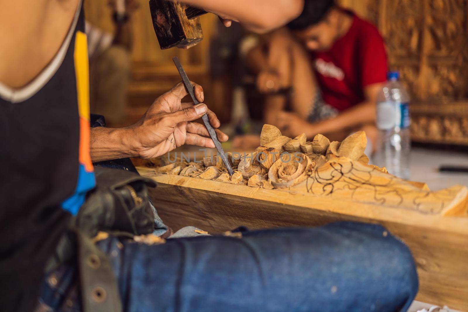 Master wood-carver made using a special knife wooden national dish - a ladle with a patterned handle. A fragment of a close-up of his hands.