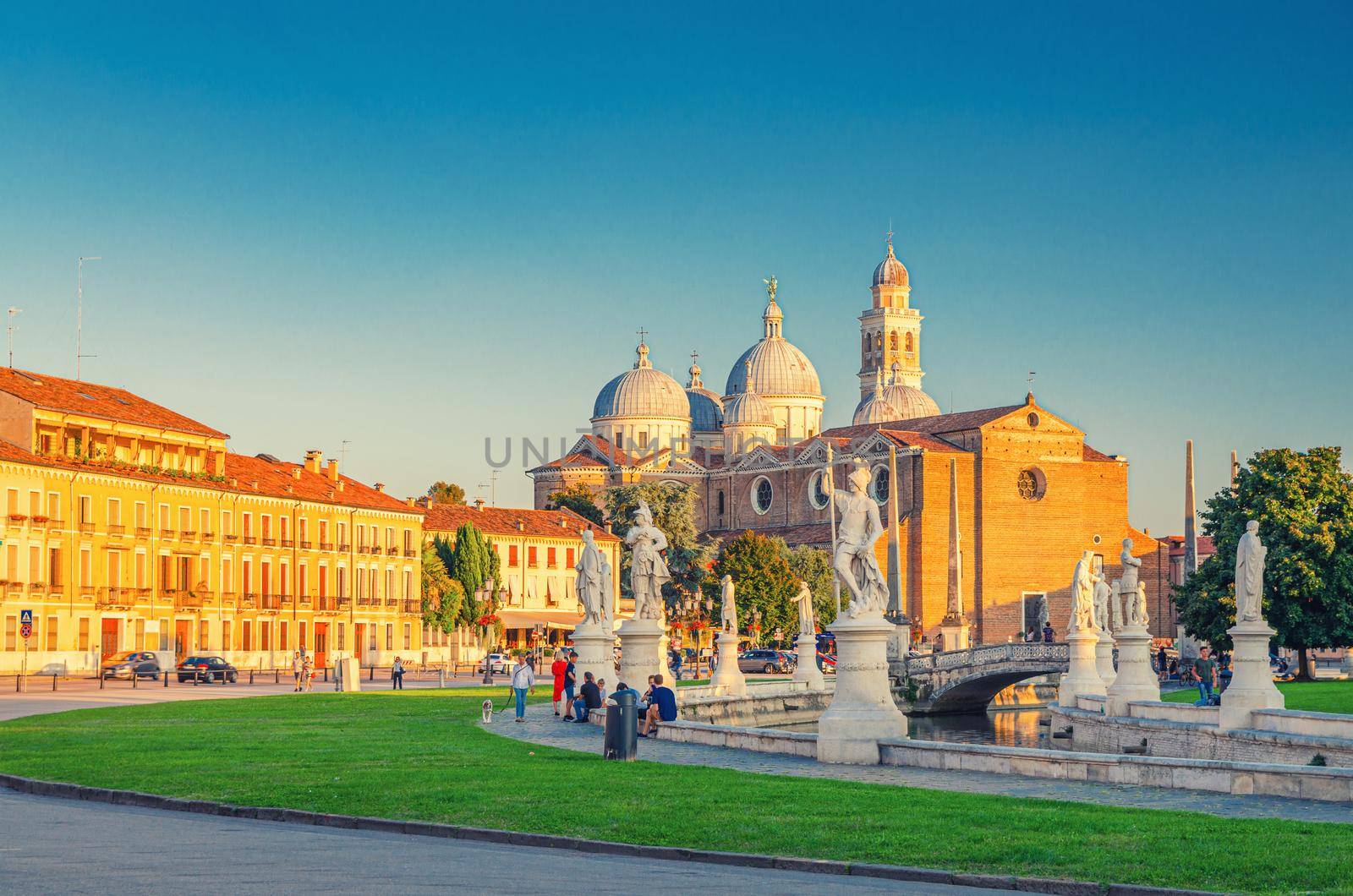 Prato della Valle square in historical city centre of Padua Padova , elliptical square with green island at the center, small canal with statues, Abbey of Santa Giustina church, Veneto Region, Italy