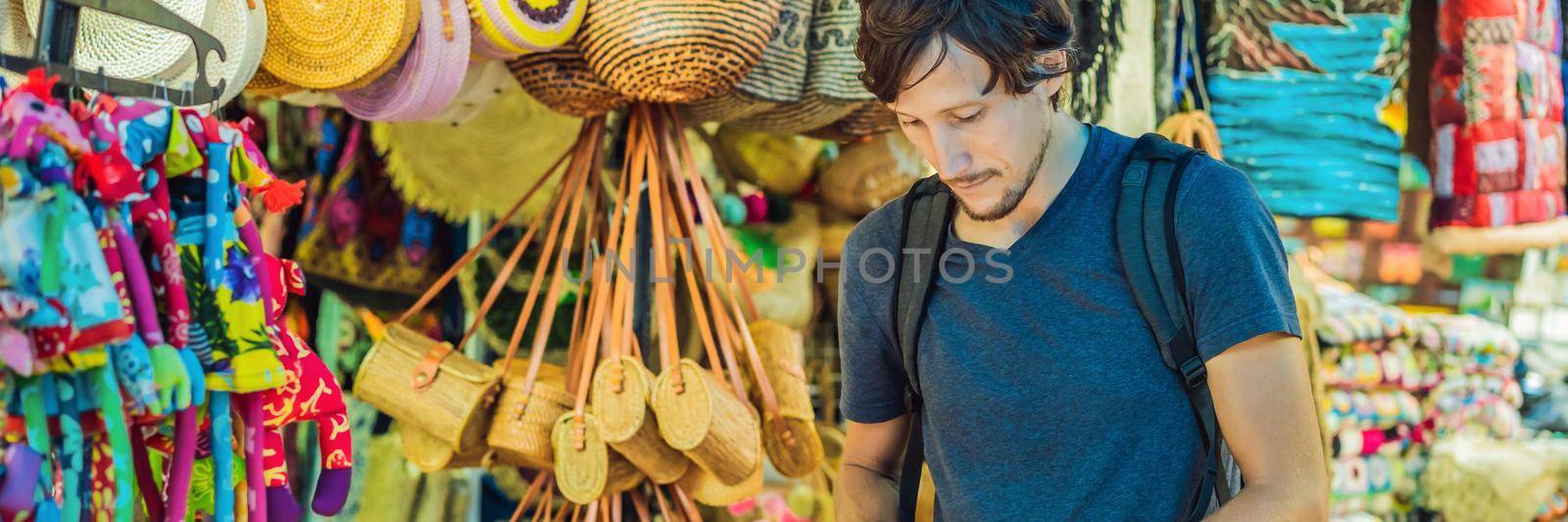 Man at a market in Ubud, Bali. Typical souvenir shop selling souvenirs and handicrafts of Bali at the famous Ubud Market, Indonesia. Balinese market. Souvenirs of wood and crafts of local residents BANNER, LONG FORMAT by galitskaya