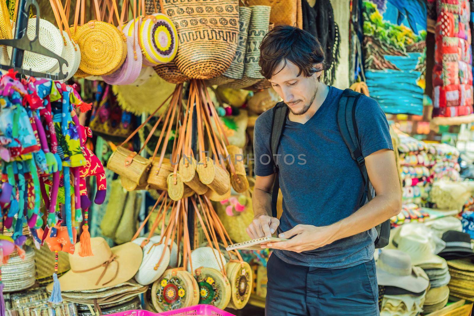 Man at a market in Ubud, Bali. Typical souvenir shop selling souvenirs and handicrafts of Bali at the famous Ubud Market, Indonesia. Balinese market. Souvenirs of wood and crafts of local residents.