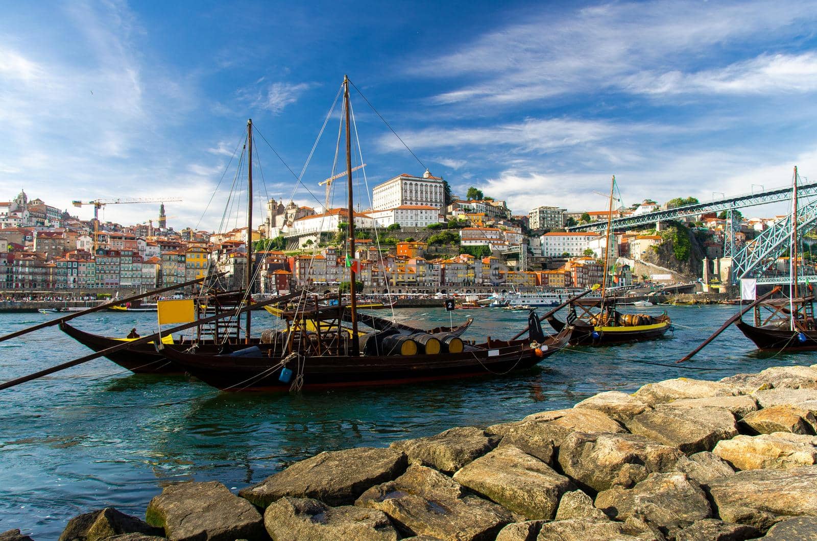 Portugal, city landscape Porto, wooden boats with wine port barrels on Douro river, panoramic view of the old town Porto, The Eiffel Bridge view, Ponte Dom Luis, Porto in summer, colored houses