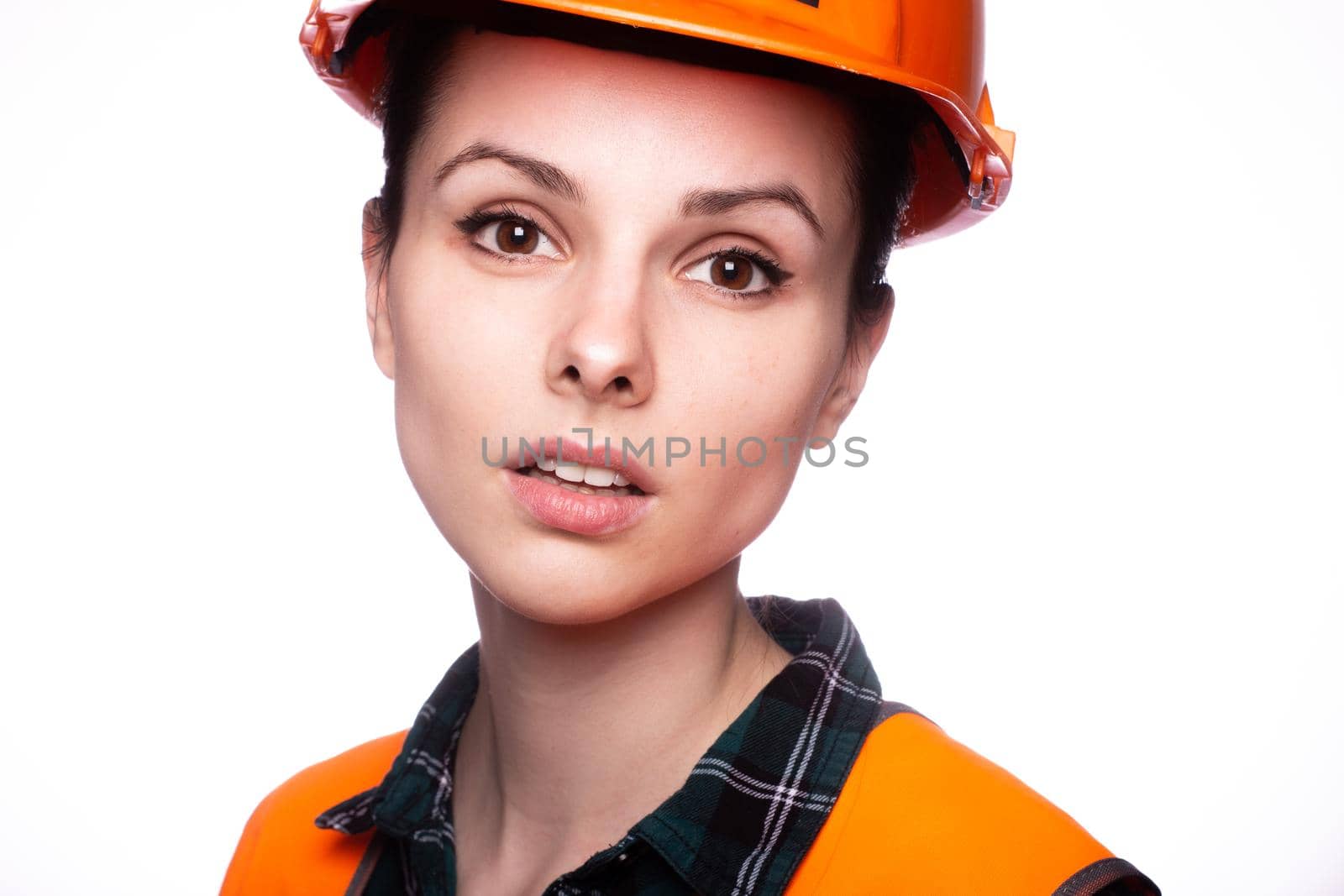 woman in construction safety helmet and orange vest, close-up portrait by shilovskaya