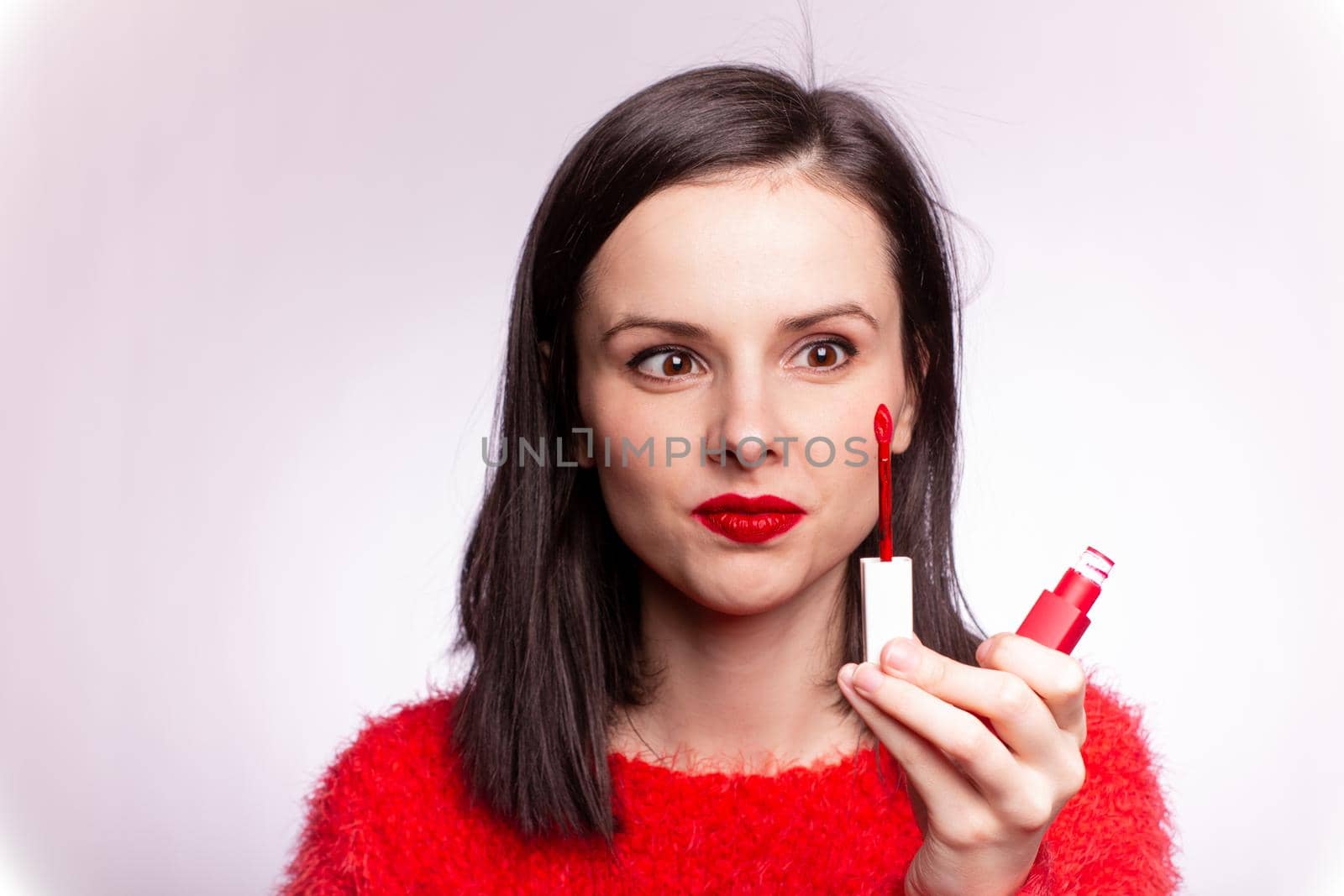 beautiful young woman paints lips with lipstick. High quality photo