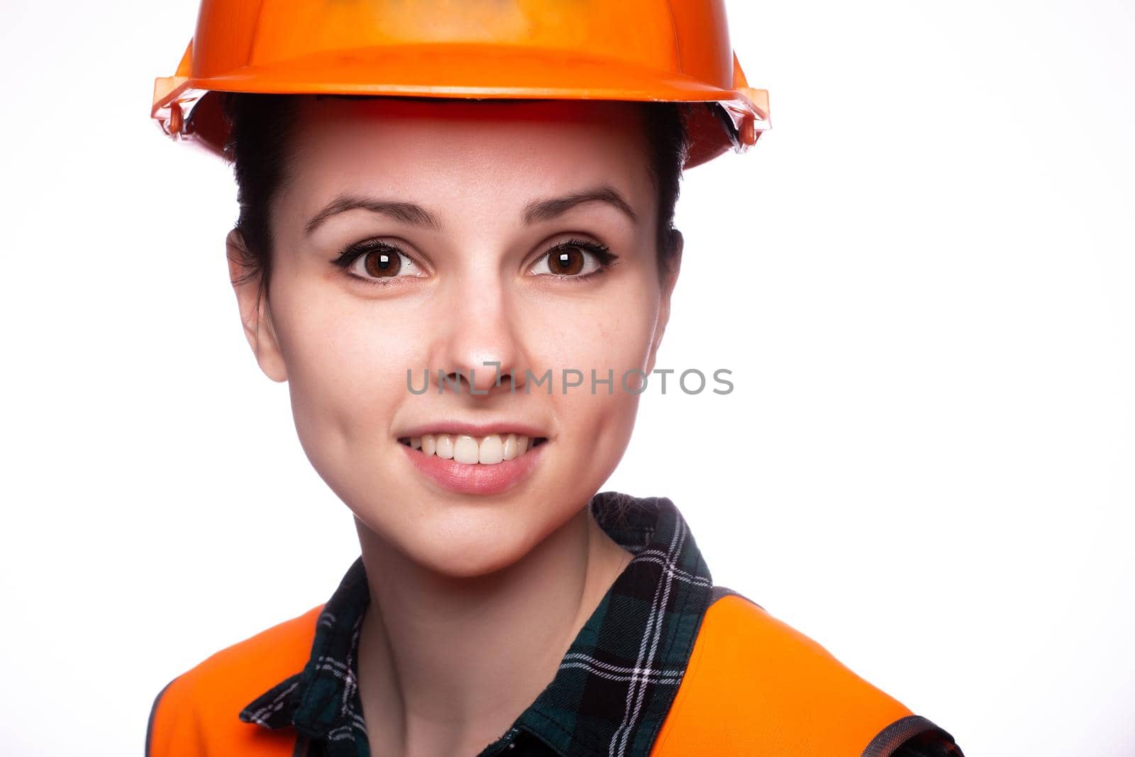 woman in construction safety helmet and orange vest, close-up portrait by shilovskaya