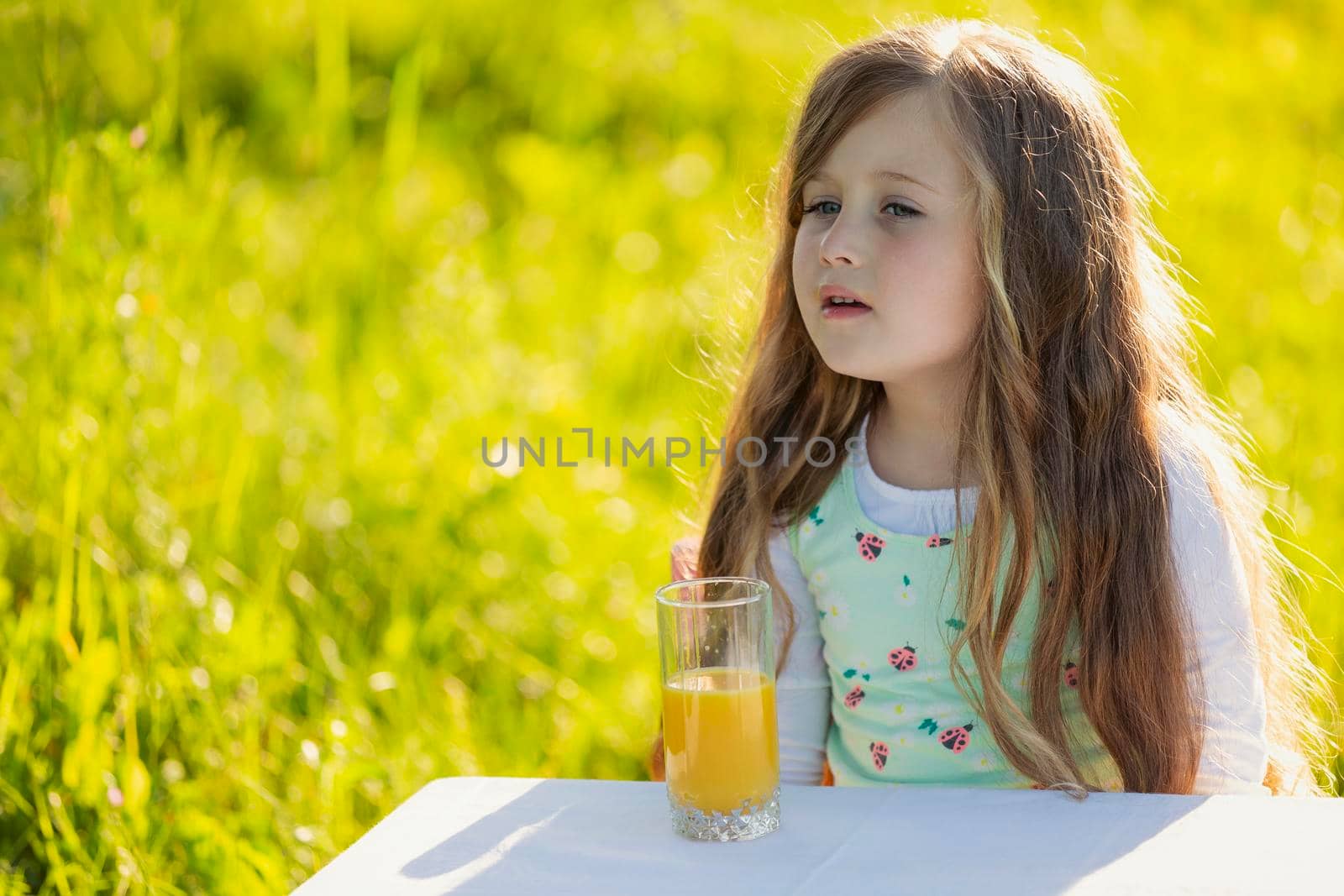 girl with a glass of orange juice in nature