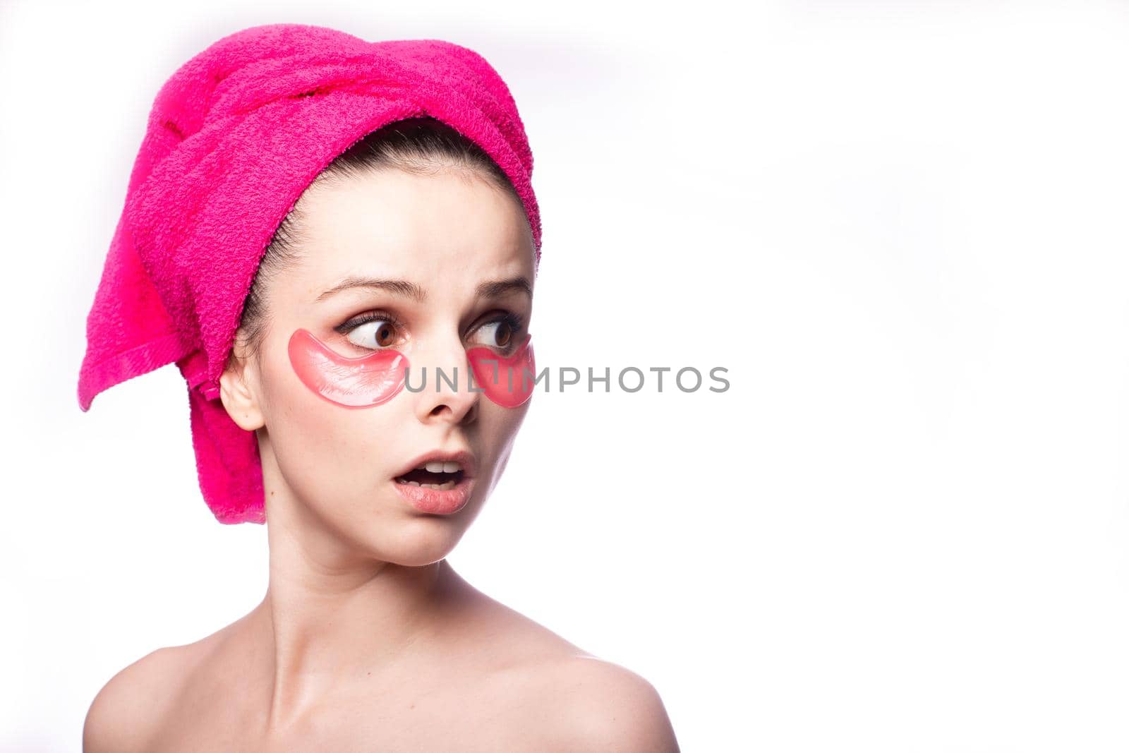 young woman after a shower in a pink towel and patches by shilovskaya