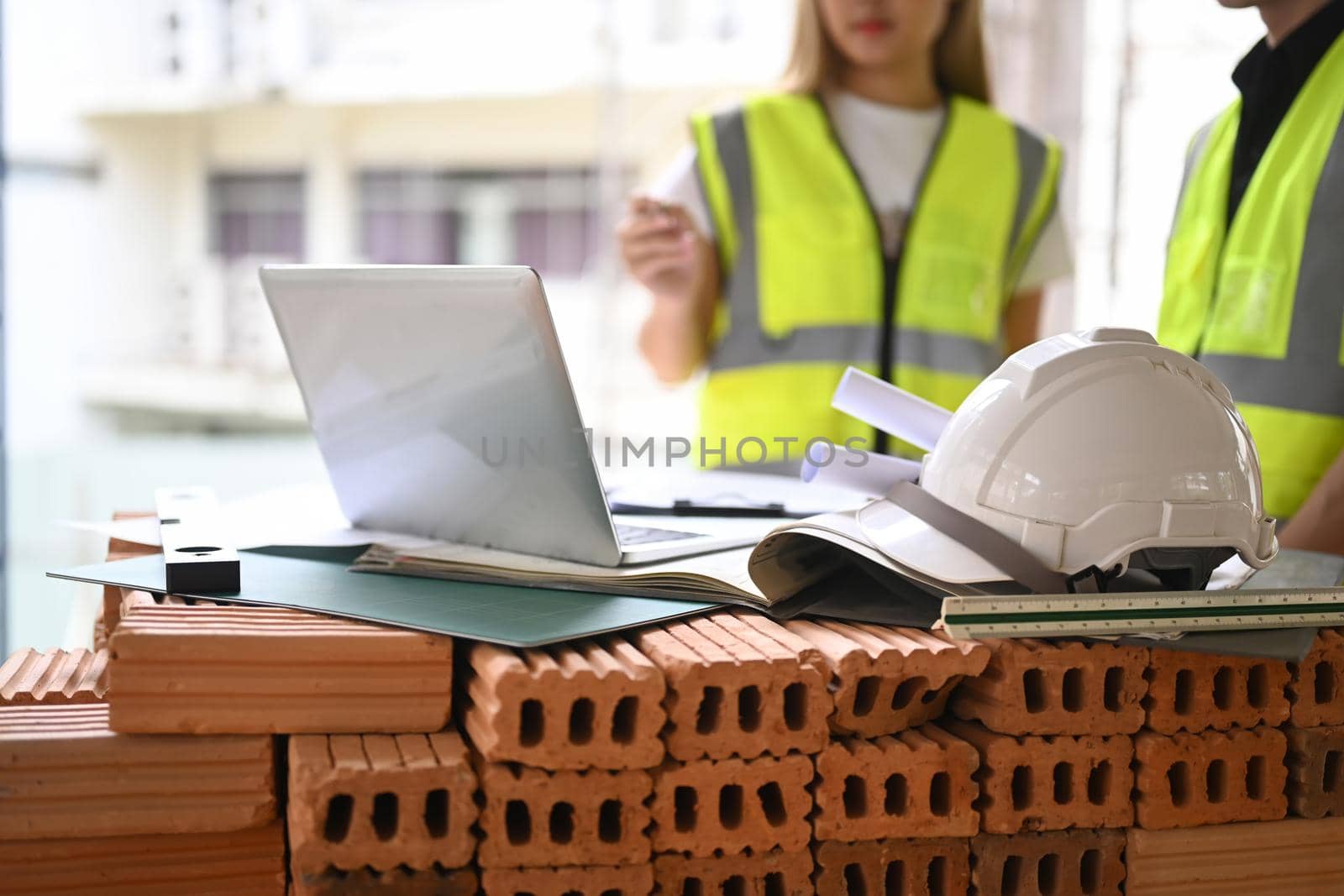 Team of young engineer and architects working, discussing, planing, measuring layout of building blueprints in construction site floor by prathanchorruangsak