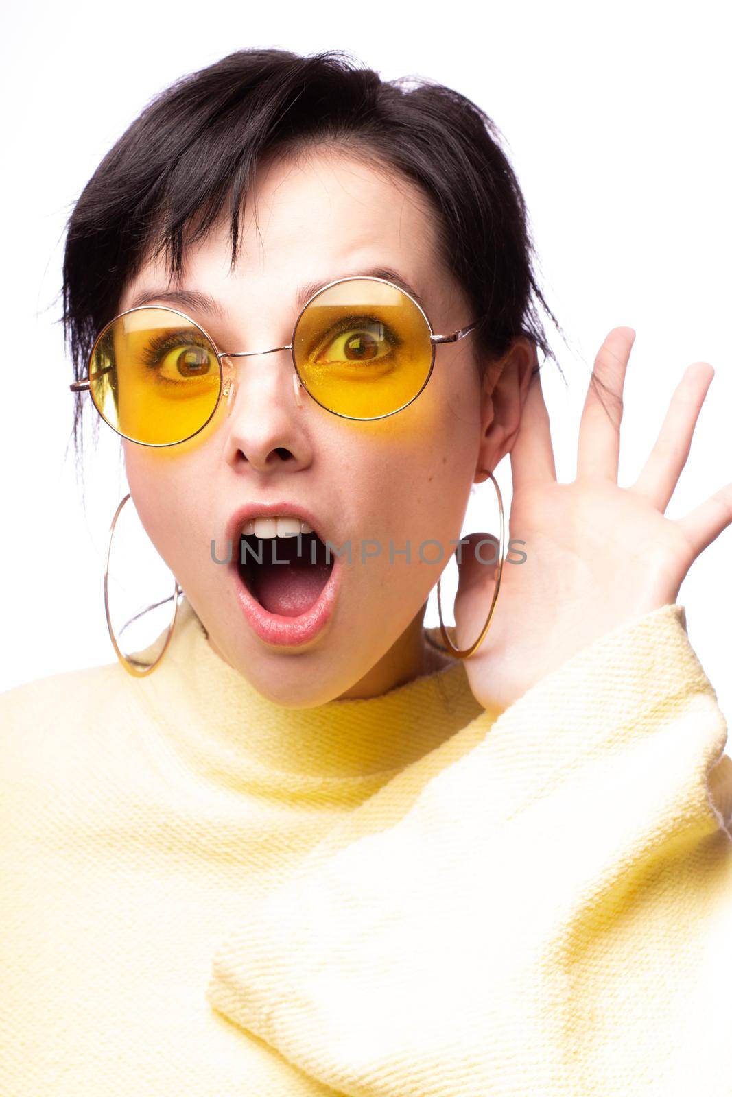 brunette woman in yellow glasses and yellow sweater, close-up portrait. High quality photo