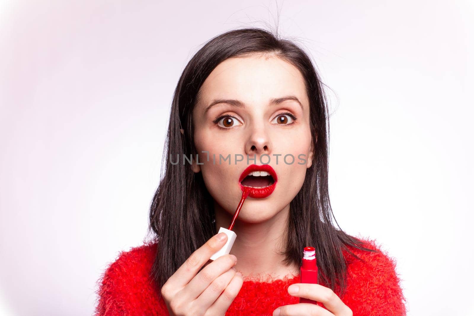 beautiful young woman paints lips with lipstick by shilovskaya