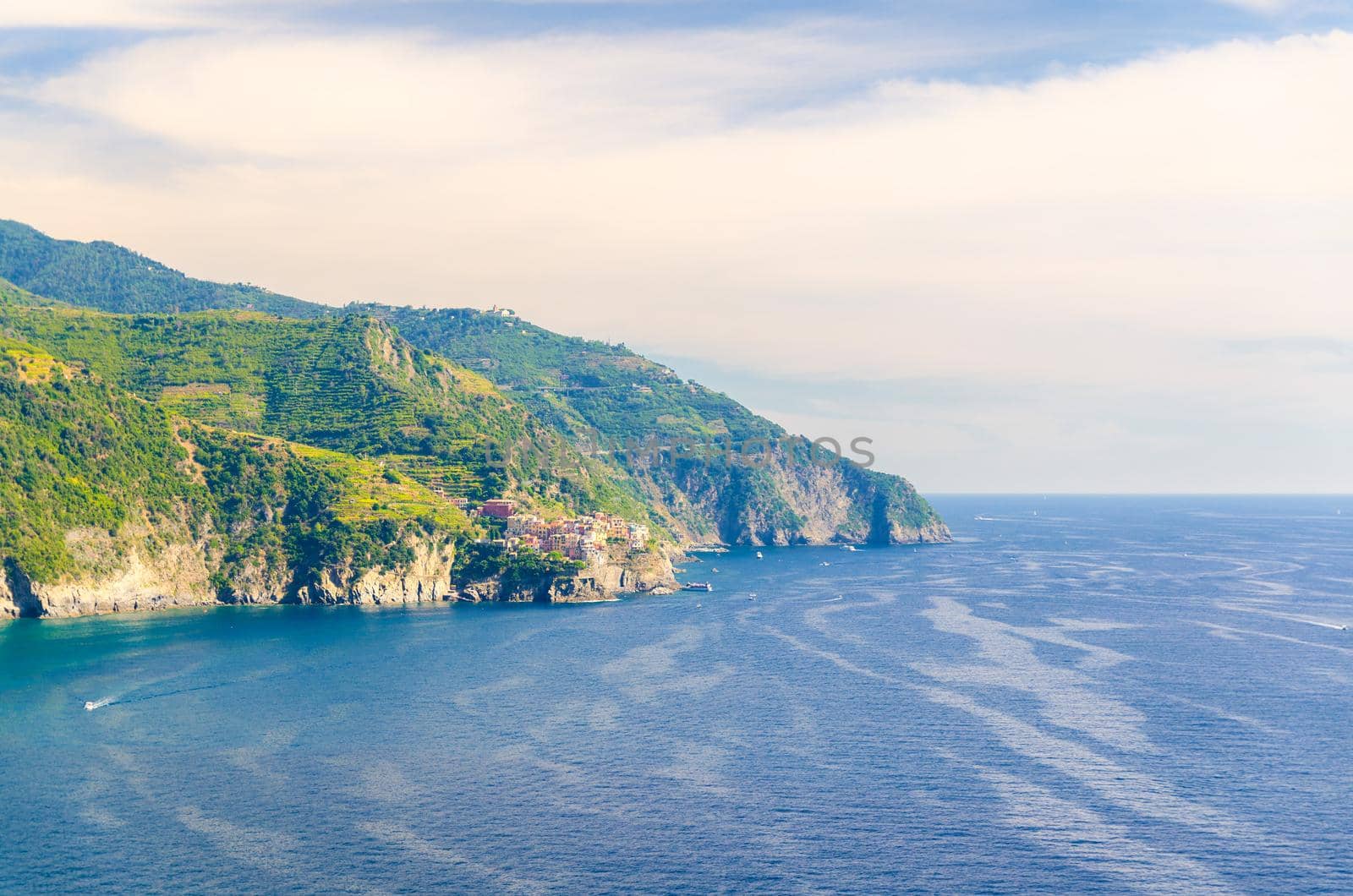 Aerial top panoramic view of Manarola village on cliff and Gulf of Genoa, Ligurian Sea, coastline of Riviera di Levante, National park Cinque Terre, blue sky copy space, La Spezia, Liguria, Italy