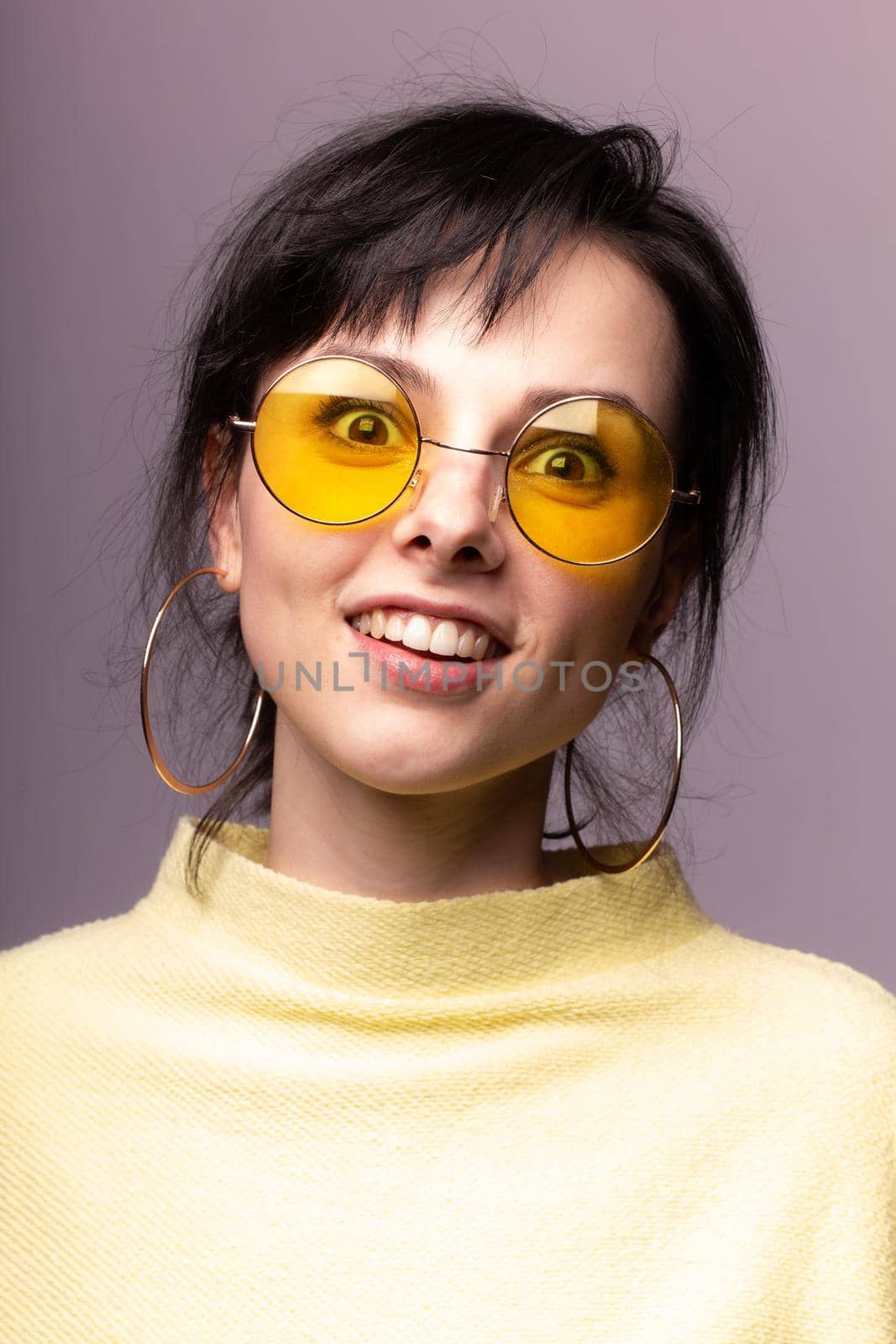 brunette woman in yellow glasses and yellow sweater, close-up portrait by shilovskaya