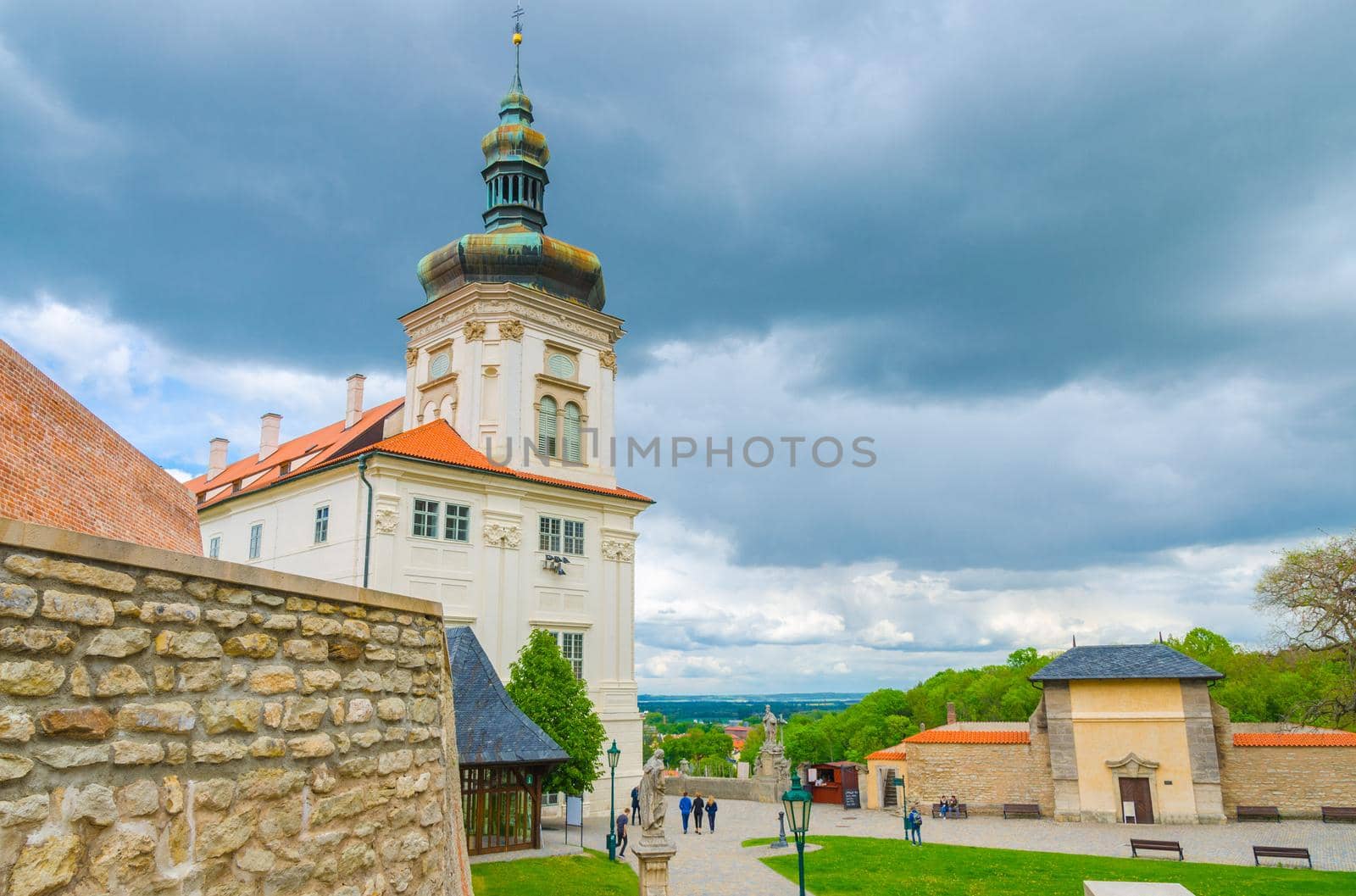 Building and green grass lawn in Park, Kutna Hora historical Town Centre, blue dramatic sky background, Central Bohemian Region, Czech Republic