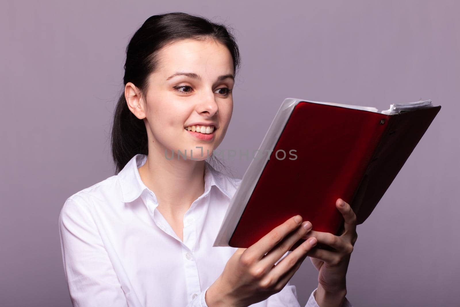 woman in a white shirt holds a red notebook in hand by shilovskaya