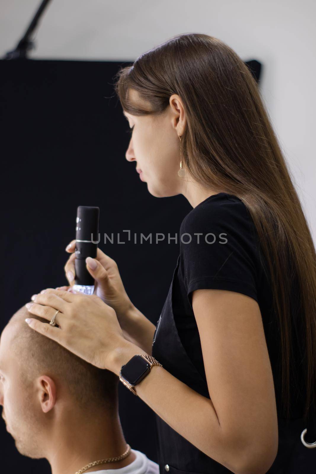 Trichoscope examination of hair, scalp and hair follicles of a young man. Copy space. The head of a man with thinning hair during the Trichology.