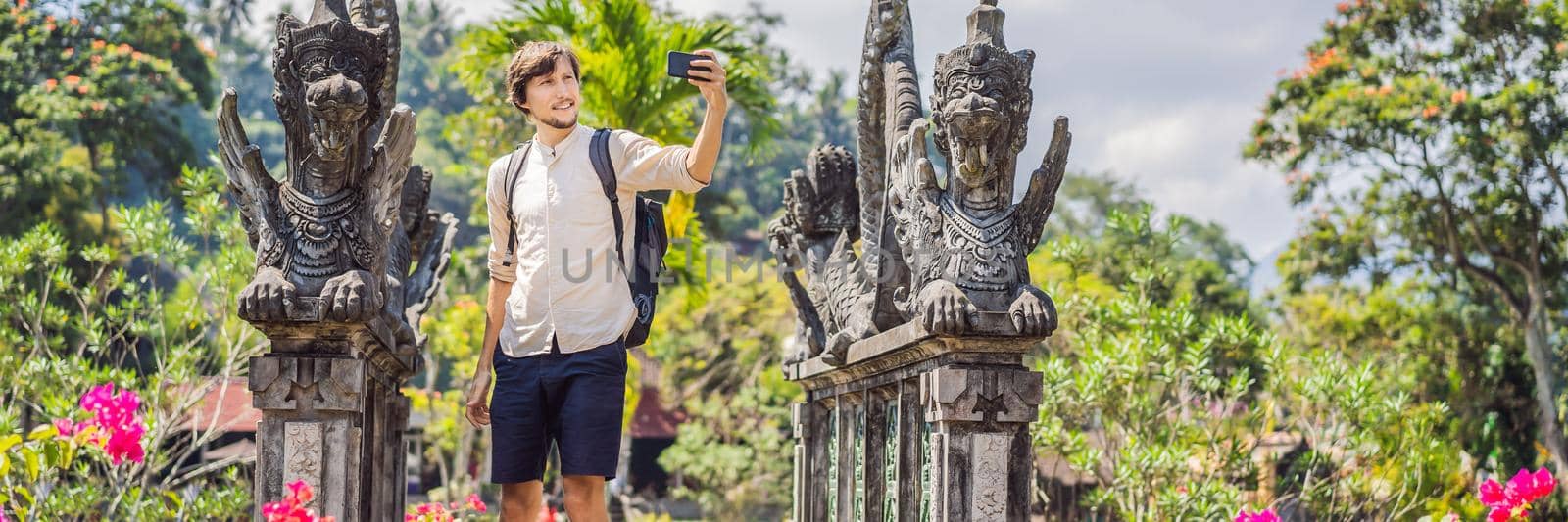 Young man tourist in Taman Tirtagangga, Water palace, Water park, Bali Indonesia BANNER, LONG FORMAT by galitskaya