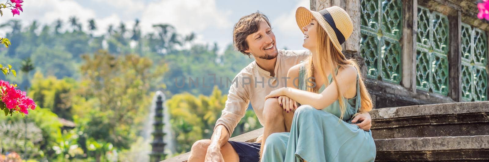 Happy loving couple in Taman Tirtagangga, Water palace, Water park, Bali Indonesia. Honeymoon in Bali. BANNER, LONG FORMAT