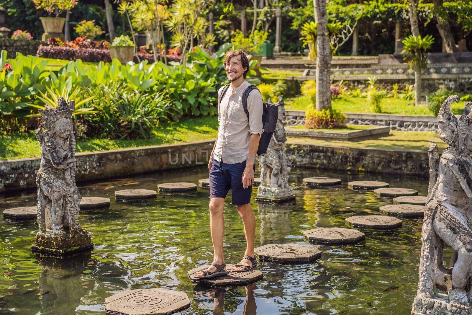 Young man tourist in Taman Tirtagangga, Water palace, Water park, Bali Indonesia.