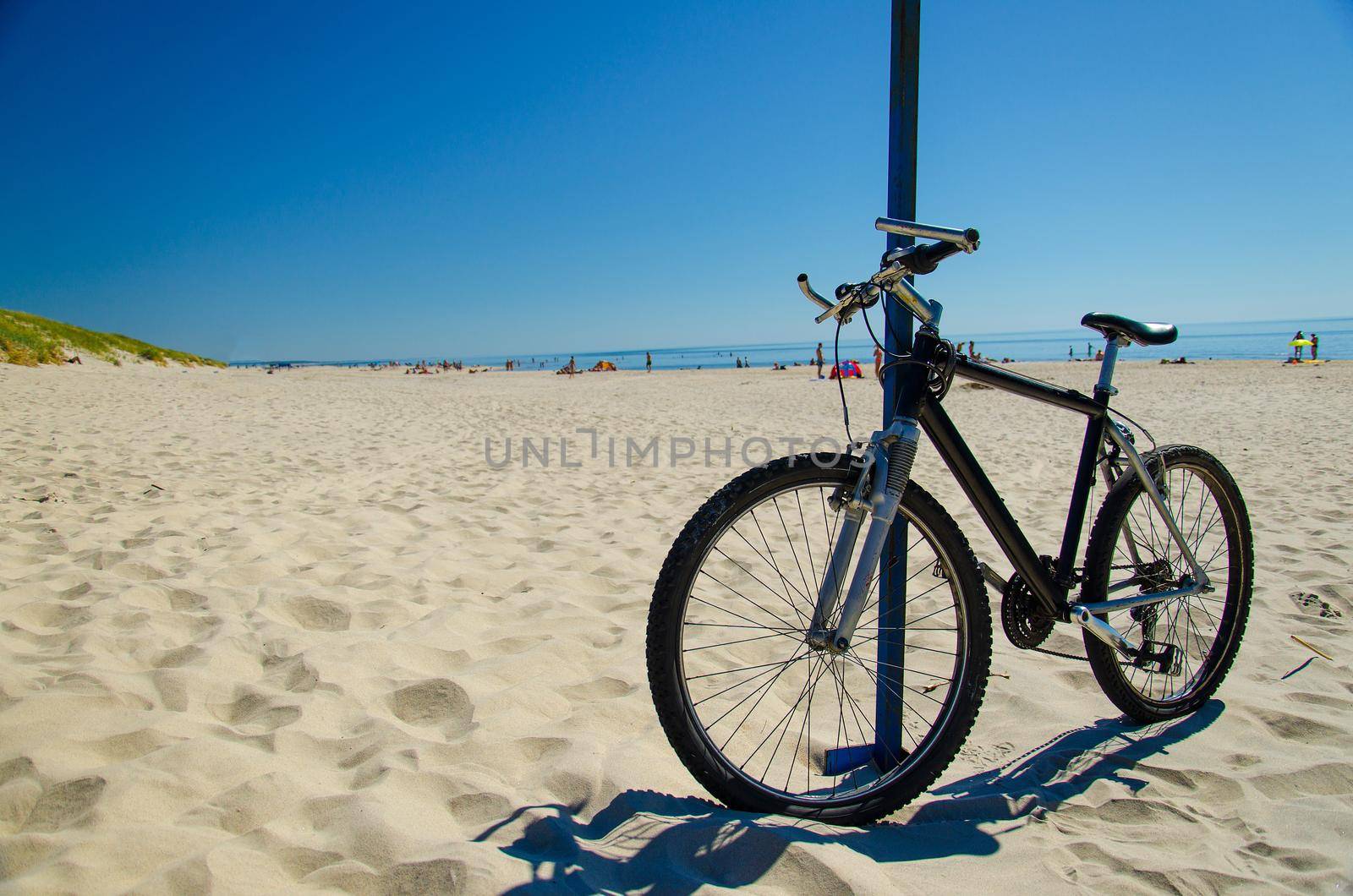 Bicycle bike on sandy yellow beach in front of blue sky in National Park Kursiu nerija, the Curonian Spit, Baltic sea, Lithuania
