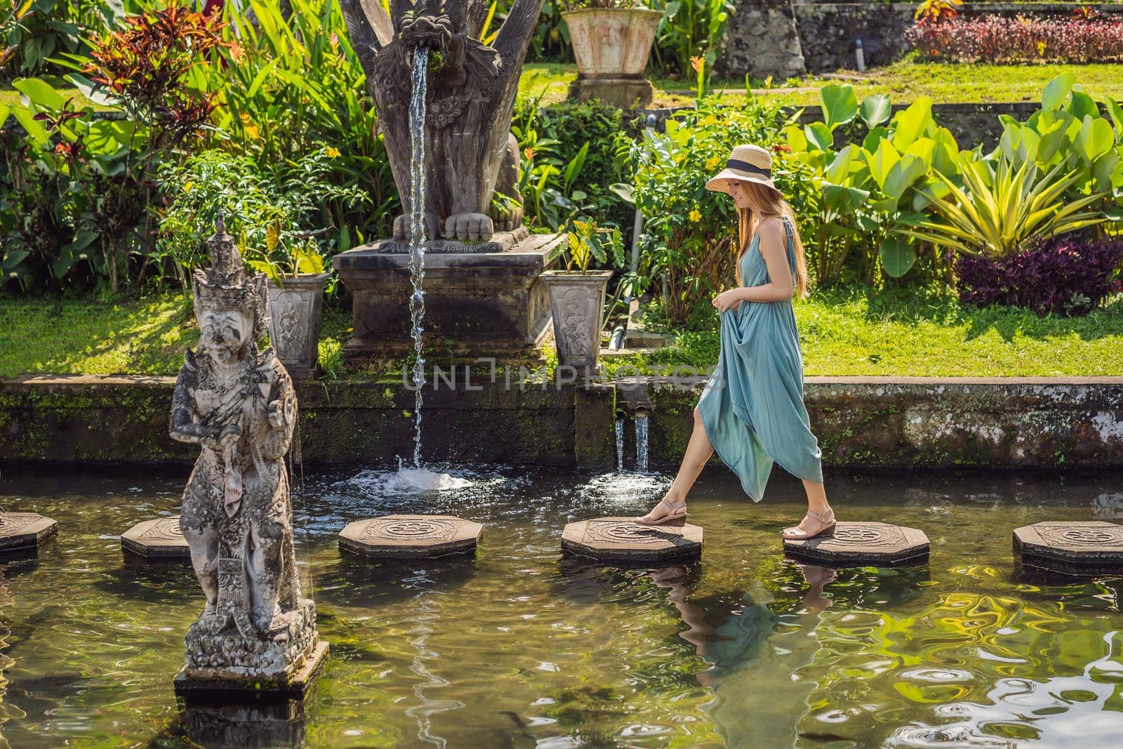 Young woman tourist in Taman Tirtagangga, Water palace, Water park, Bali Indonesia.