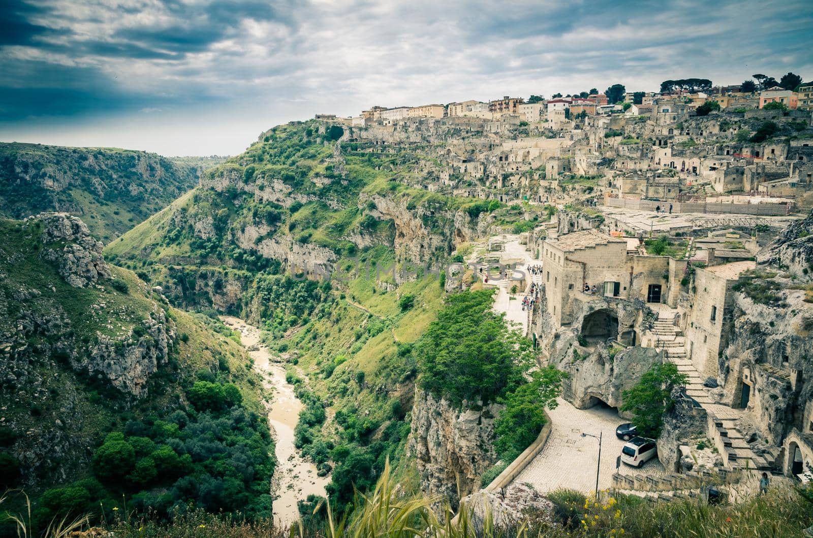 Church Chiesa San Pietro Caveoso and rock church Santa Maria De Idris near canyon in historical centre old ancient town Sassi di Matera with dramatic sky, UNESCO, Basilicata, Southern Italy