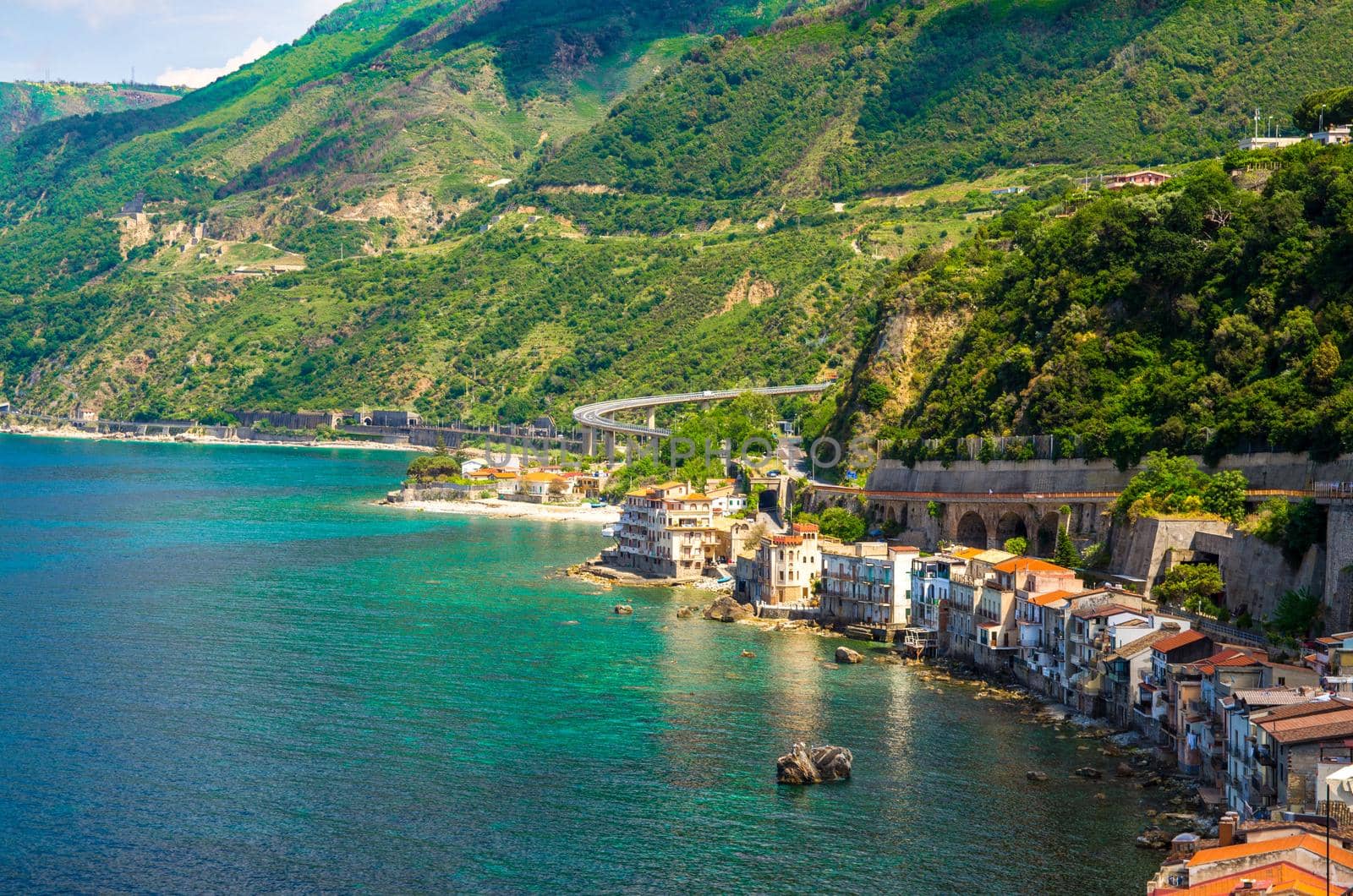 Aerial top view of houses in small fishing village Chianalea di Scilla from old medieval castle on rock Castello Ruffo and Mediterranean Tyrrhenian sea coast shore, Calabria, Southern Italy