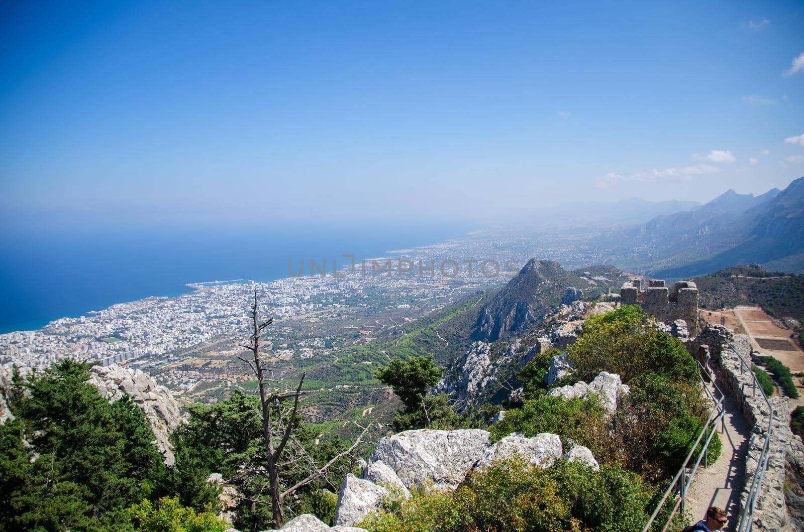 View of Kyrenia Girne mountains and town from medieval Saint Hilarion Castle in front of blue sky with white clouds and Mediterranean sea, Northern Cyprus