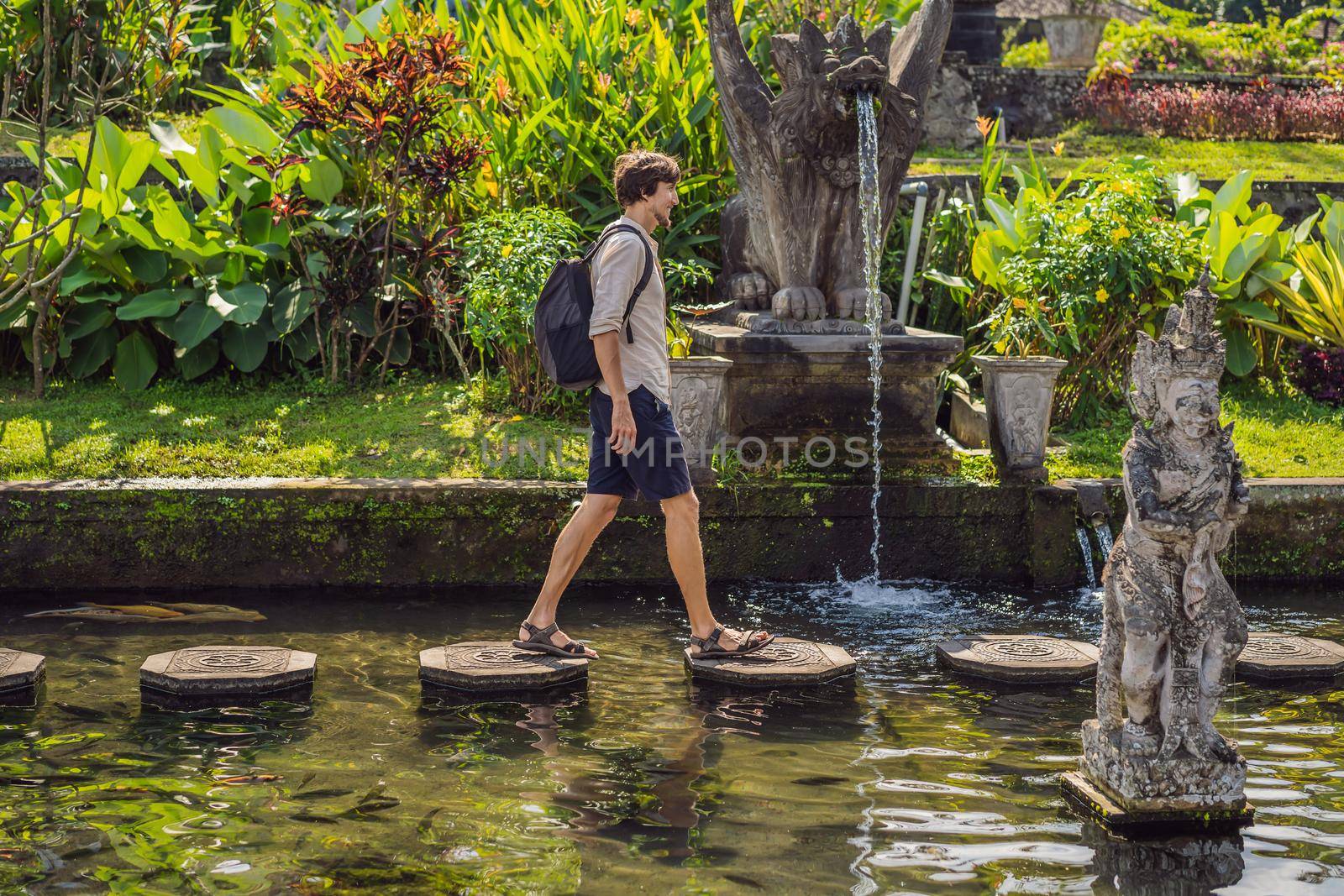 Young man tourist in Taman Tirtagangga, Water palace, Water park, Bali Indonesia.