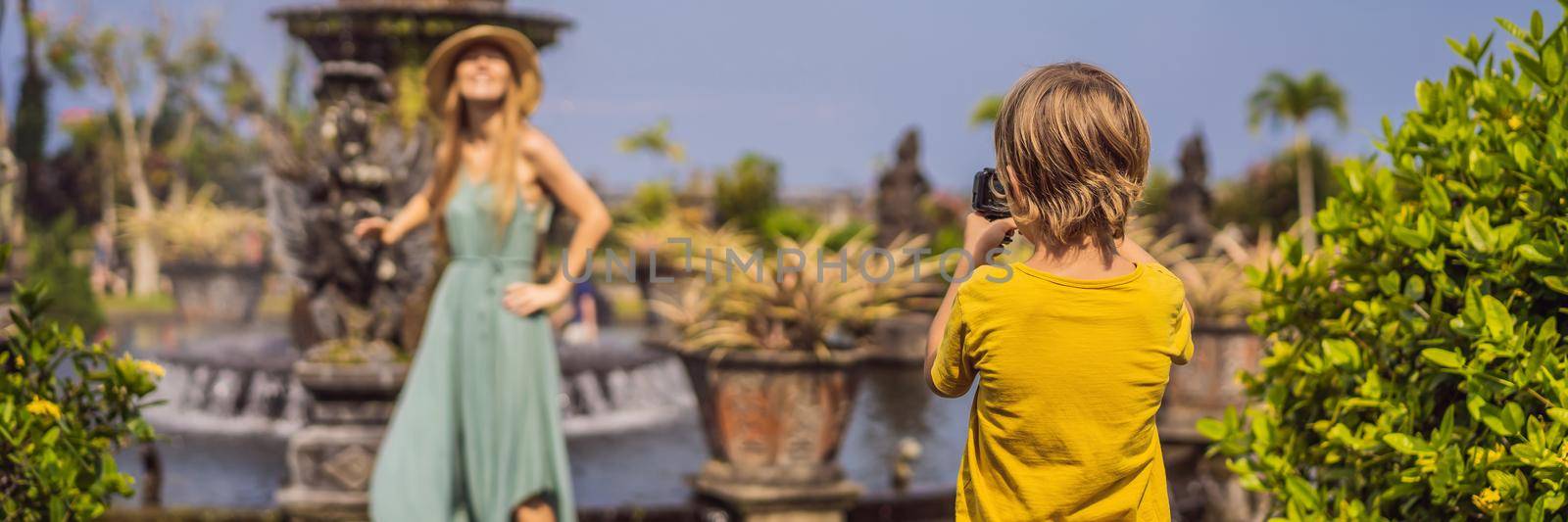 Mom and son tourists in Taman Tirtagangga, Water palace, Water park, Bali Indonesia. Traveling with children concept. Kids friendly place BANNER, LONG FORMAT by galitskaya