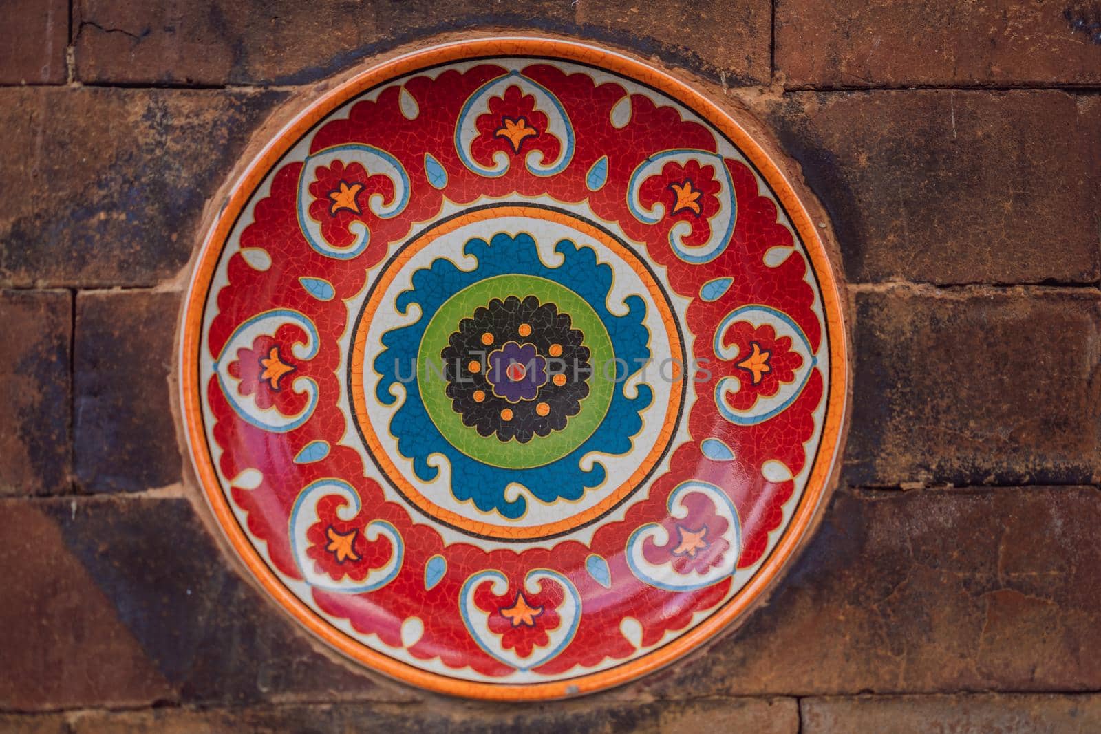 Balinese decoration, painted plate on a stone wall.