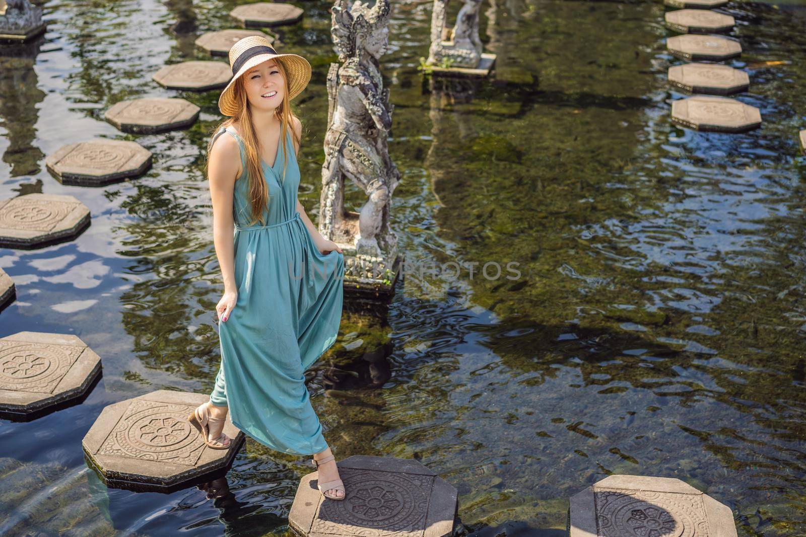 Young woman tourist in Taman Tirtagangga, Water palace, Water park, Bali Indonesia.