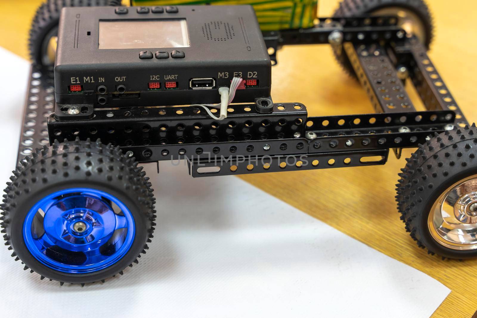 a programmable children's robot car in the form of a platform on wheels with a controller, assembled from designer parts. A robot car controlled by a computer, a modern toy. Educational technologies. education. code and programming.