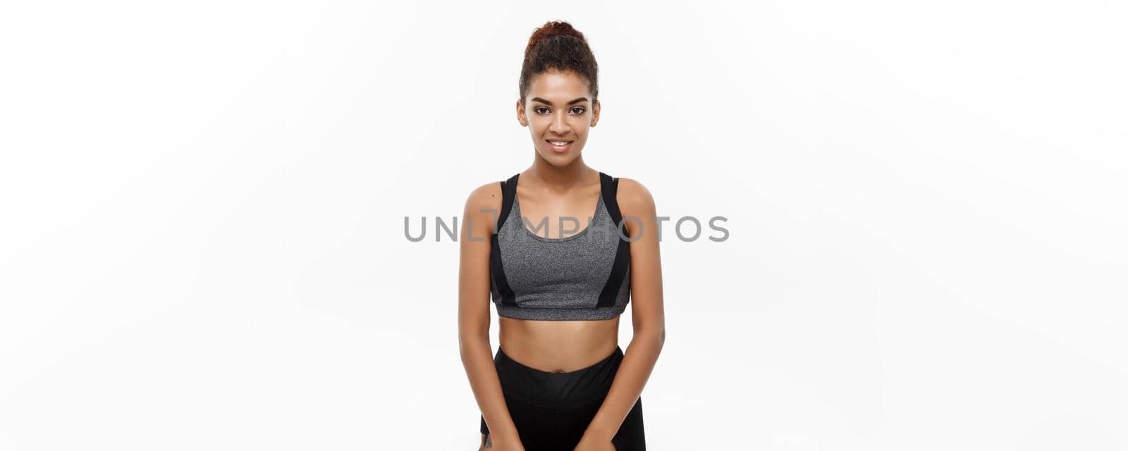 Healthy and Fitness concept - Beautiful American African lady in fitness clothes ready for workout. Isolated on white background. by Benzoix