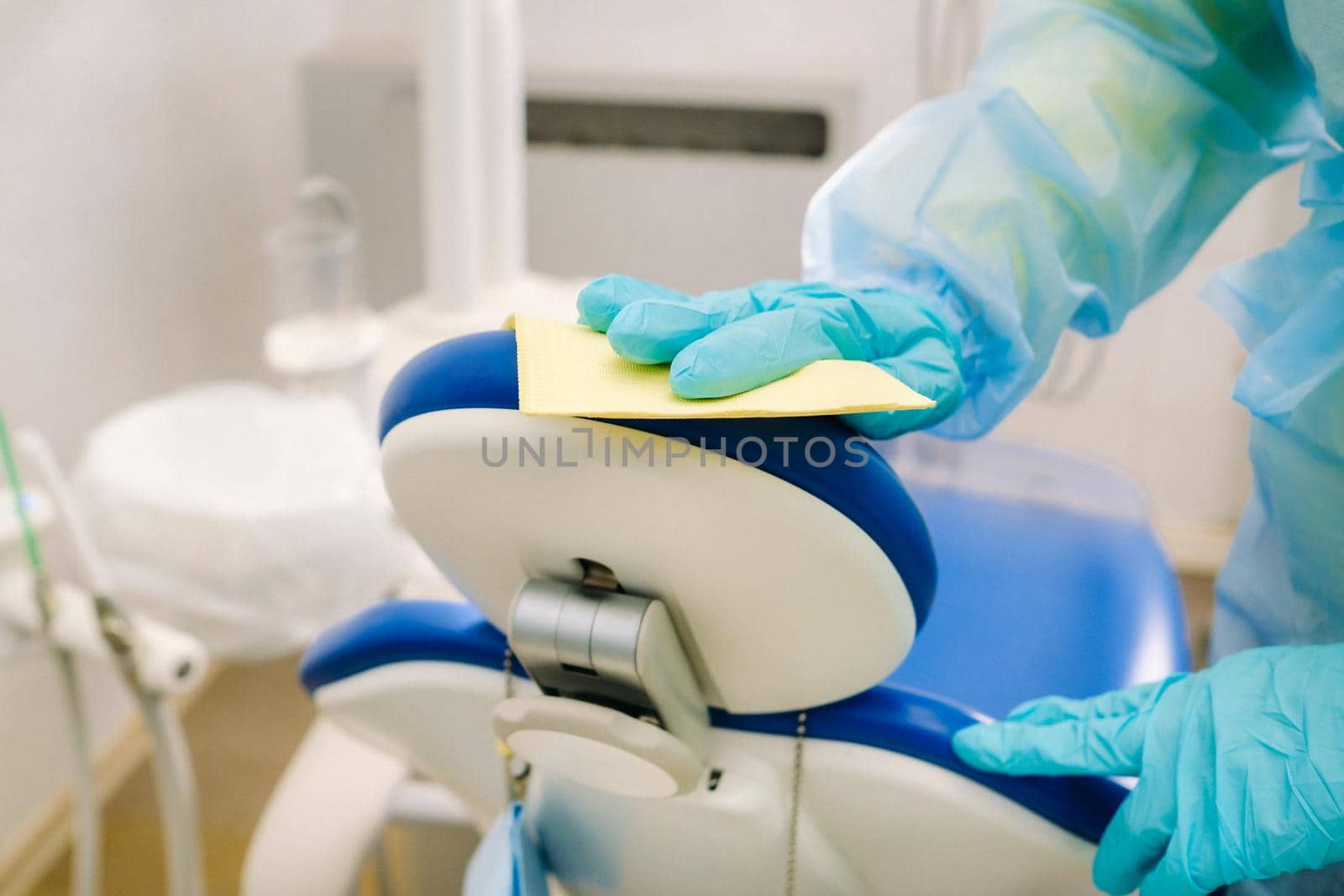 A nurse disinfects work surfaces in the dentist's office..