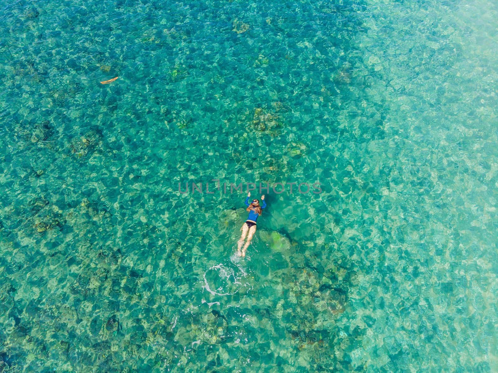 Happy woman in snorkeling mask dive underwater with tropical fishes in coral reef sea pool. Travel lifestyle, water sport outdoor adventure, swimming lessons on summer beach holiday. Aerial view from the drone.