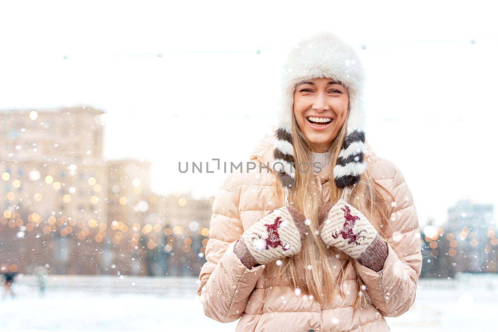 Happy winter time in big city charming girl standing street dressed funny fluffy hat. Enjoying snowfall, expressing positivity, smiling to camera, joyful cheerful mood, true emotions, Christmas mood