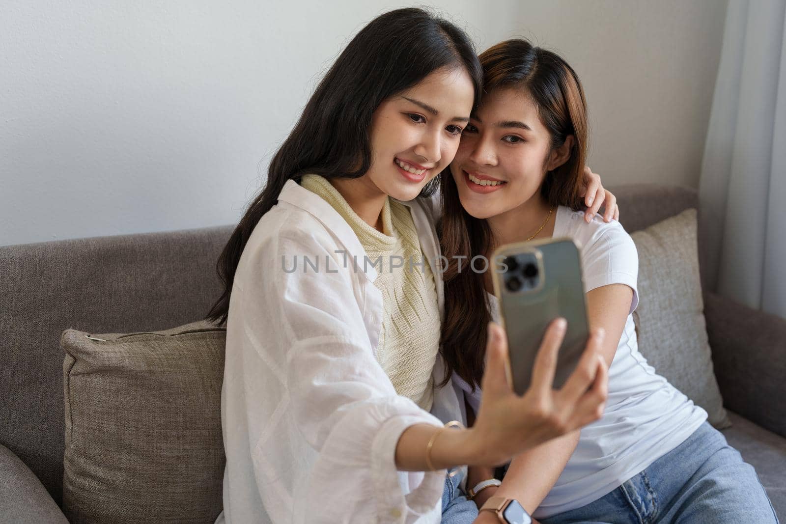 lgbtq, lgbt concept, homosexuality, portrait of two asian women enjoying together and showing love for each other while using smartphone mobile to take selfies.