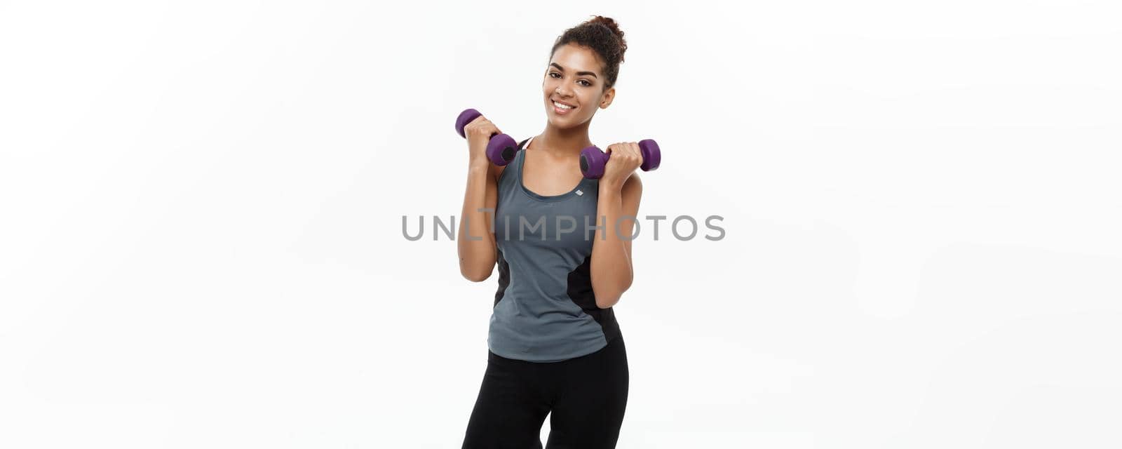 Healthy and Fitness concept - Beautiful American African lady in fitness clothes workout with dumbbell. Isolated on white background