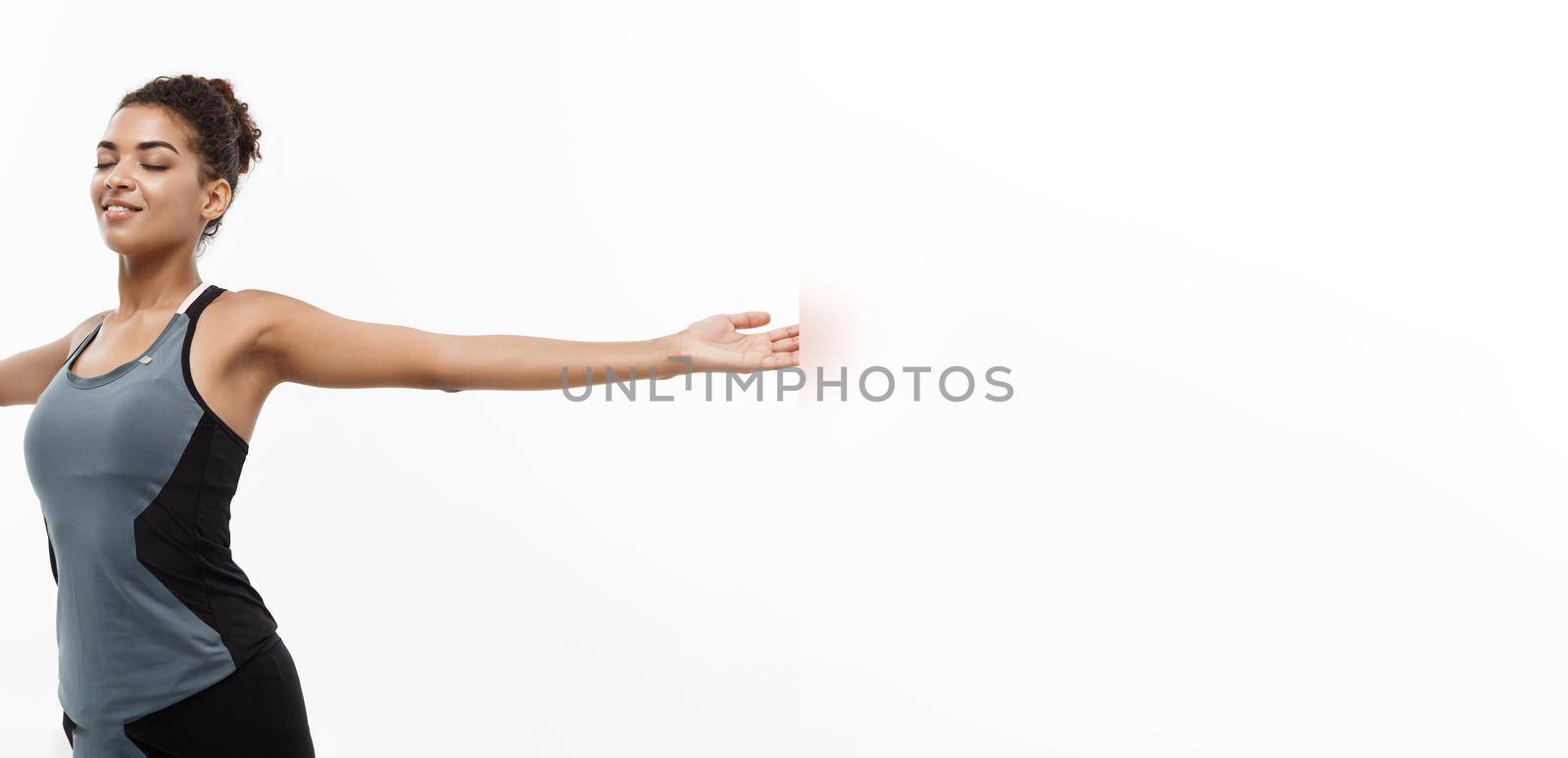 Healthy and Fitness concept - Portrait of young beautiful African American with her hands outstretched and closing eyes feeling relax. Isolated on white studio background. by Benzoix