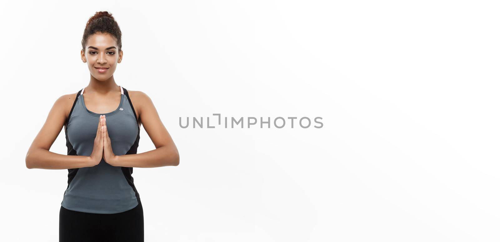 Healthy and Fitness concept - Beautiful American African lady in fitness clothing doing yoga and meditation. Isolated on white background. by Benzoix