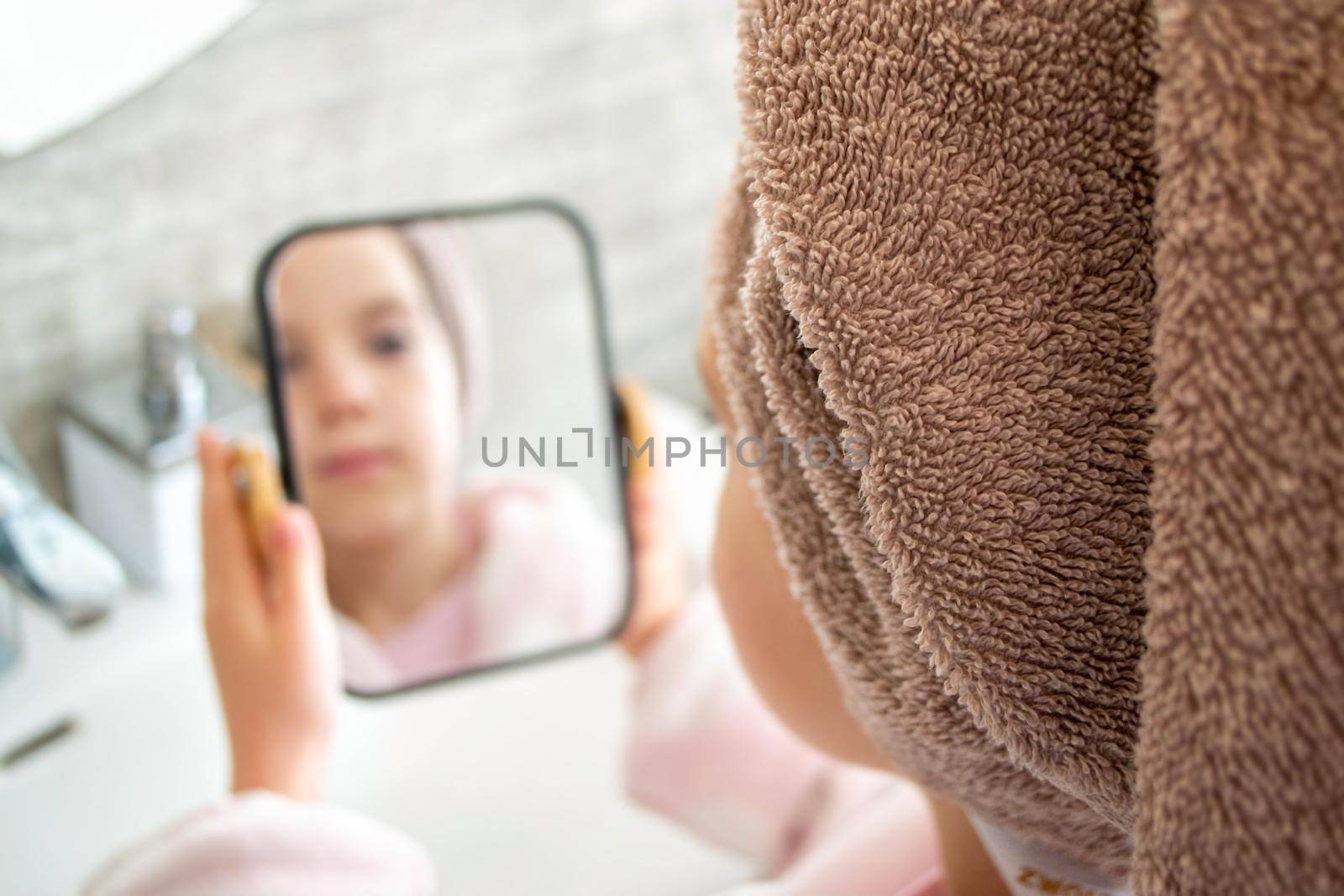 Relaxed young girl model wears towel wrapped on head, feels refreshed after taking shower, has healthy clean soft skin, poses in cozy bathroom. Girl, beauty and hygiene concept. High quality photo