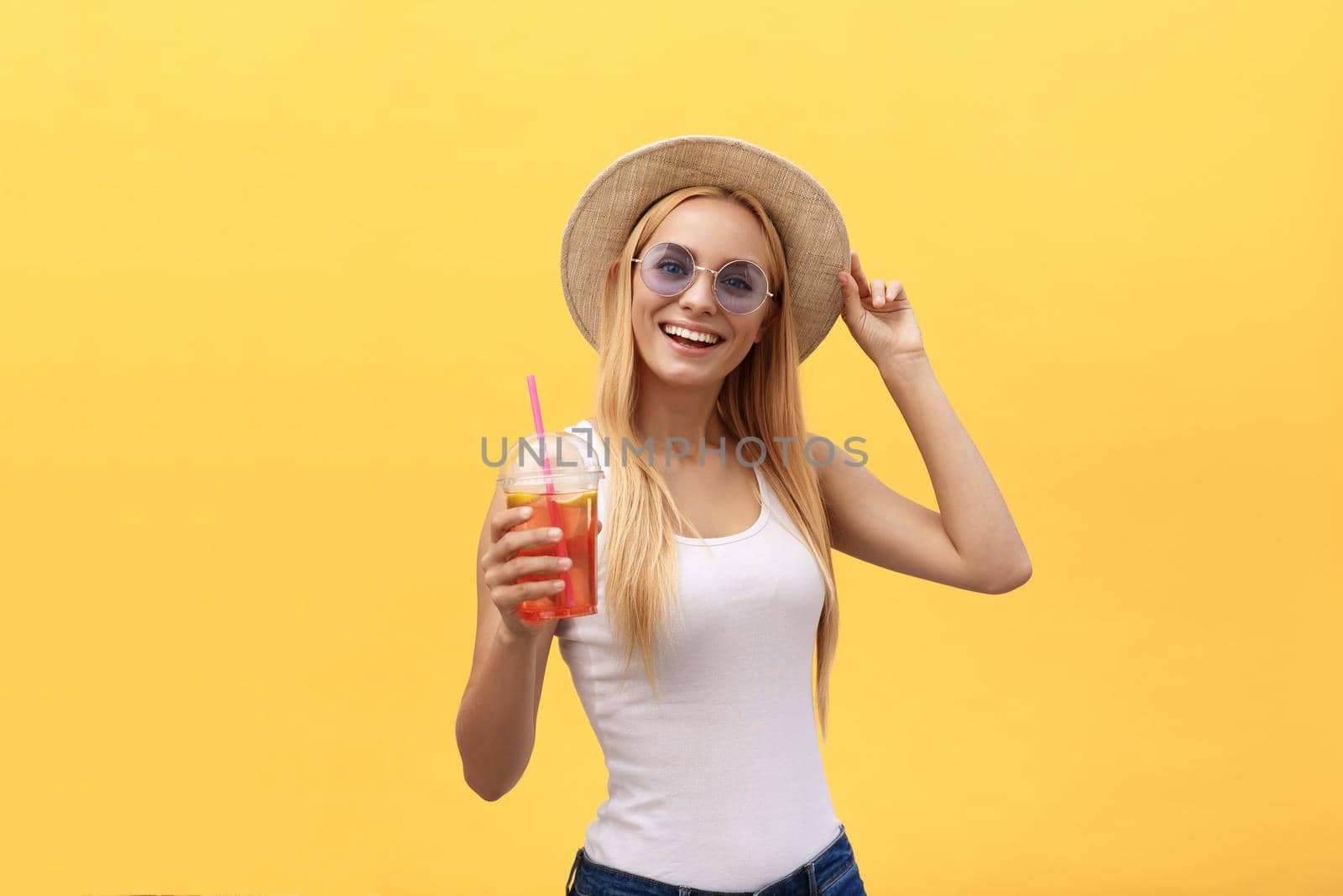 Happy stylish modern woman with modern shaped sunglasses laughing looking at you camera isolated on yellow background. Happiness concept.