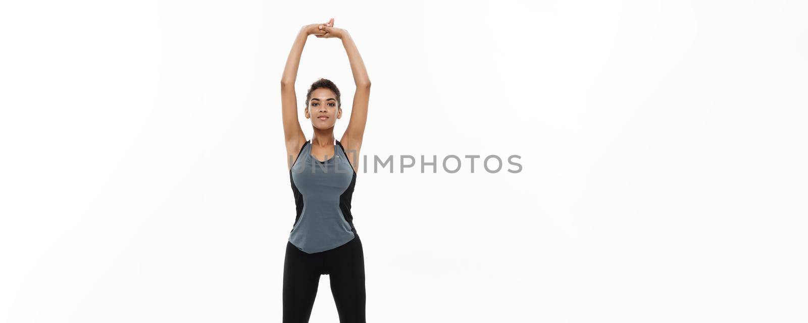 Sport, training, lifestyle and Fitness concept - Full-length portrait of beautiful happy African American woman stretching hands. Isolated on white studio background. by Benzoix