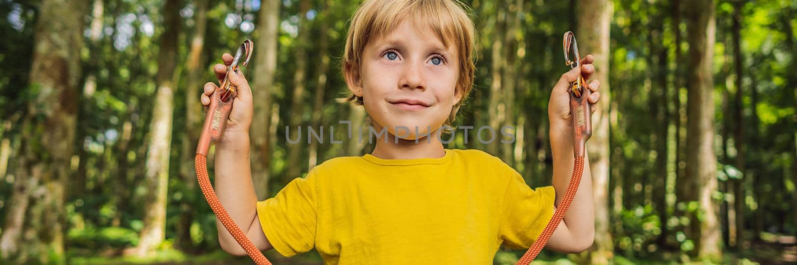 Little boy in a rope park. Active physical recreation of the child in the fresh air in the park. Training for children BANNER, LONG FORMAT by galitskaya