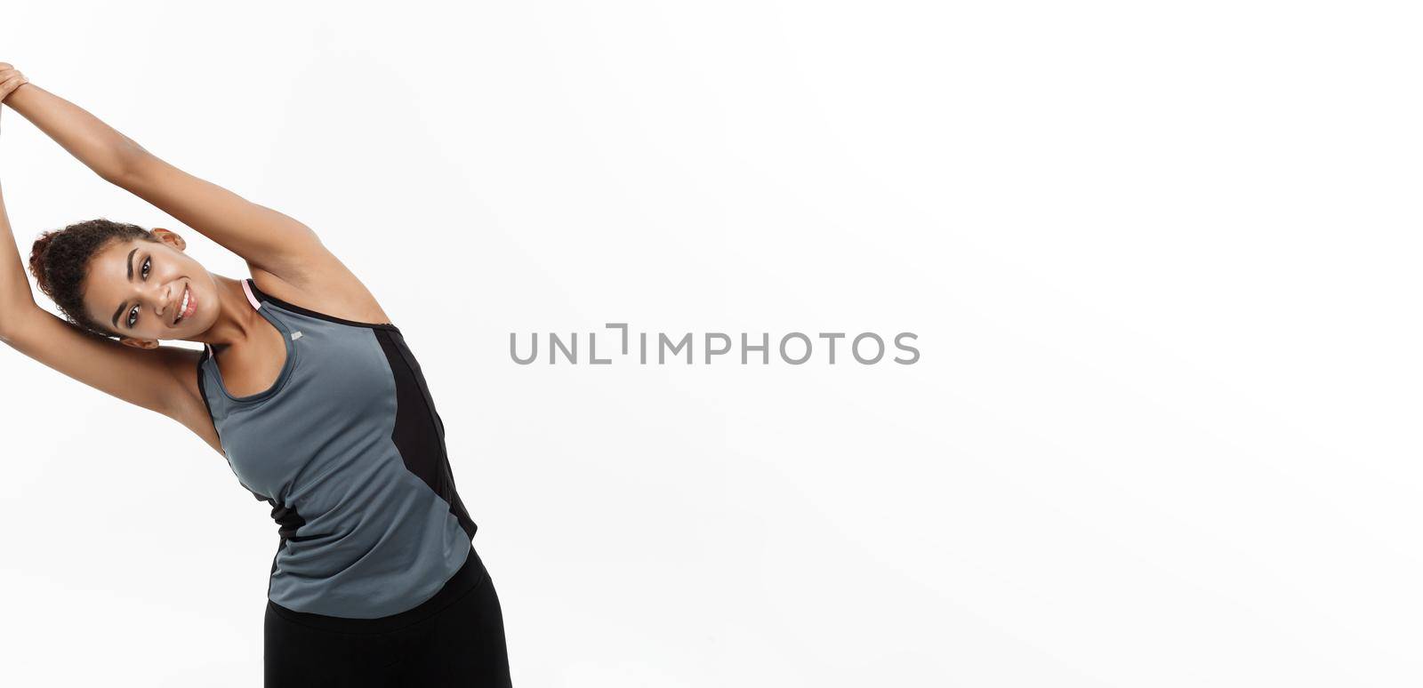 Sport, training, lifestyle and Fitness concept - portrait of beautiful happy African American woman stretching hands. Isolated on white studio background. by Benzoix