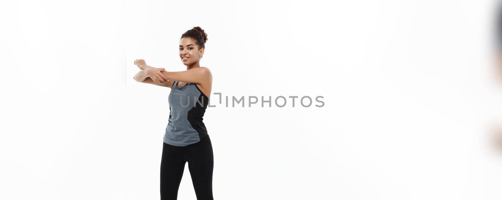 Sport, training, lifestyle and Fitness concept - Full-length portrait of beautiful happy African American woman stretching hands. Isolated on white studio background