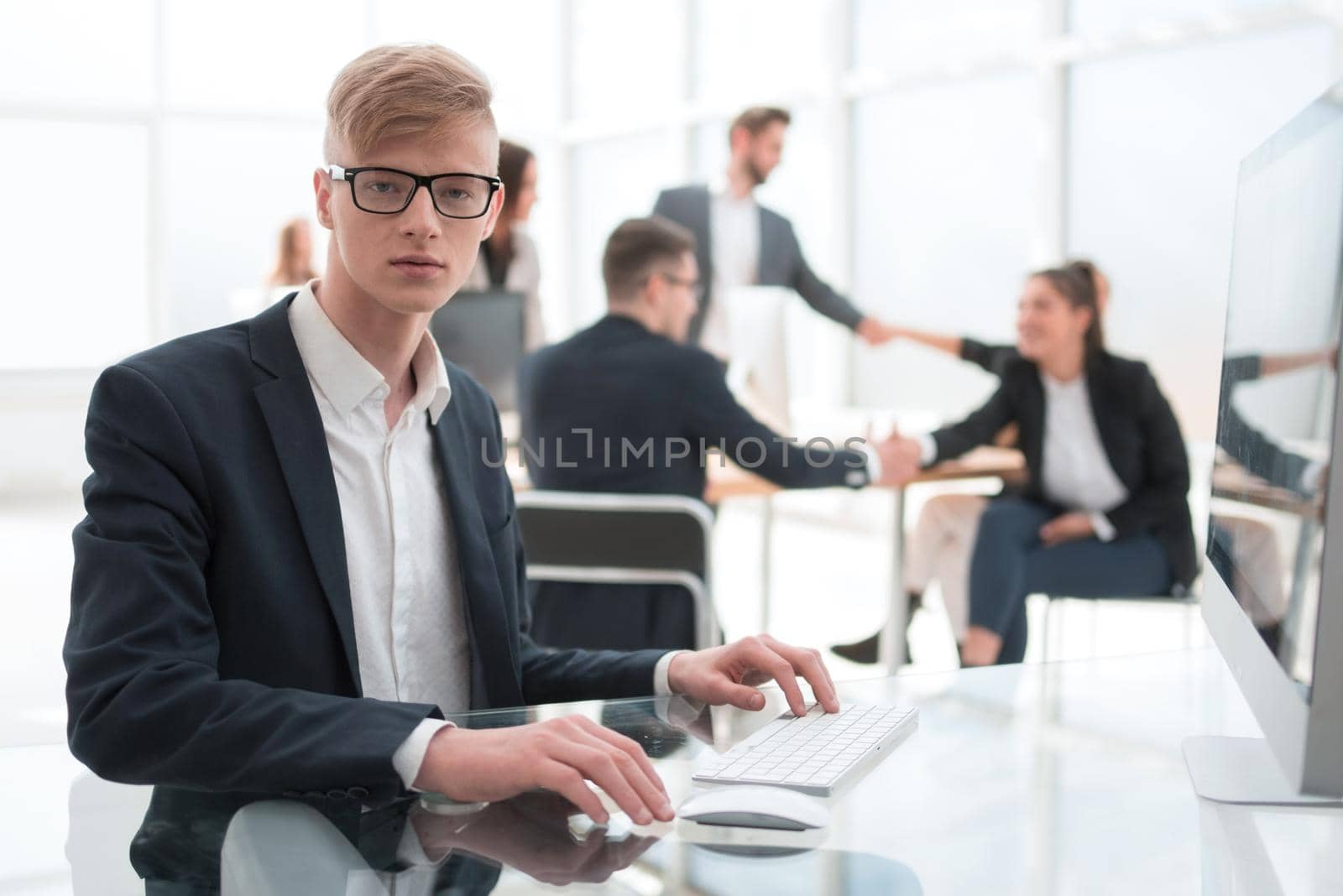 confident young employee in the workplace in the office. people and technology