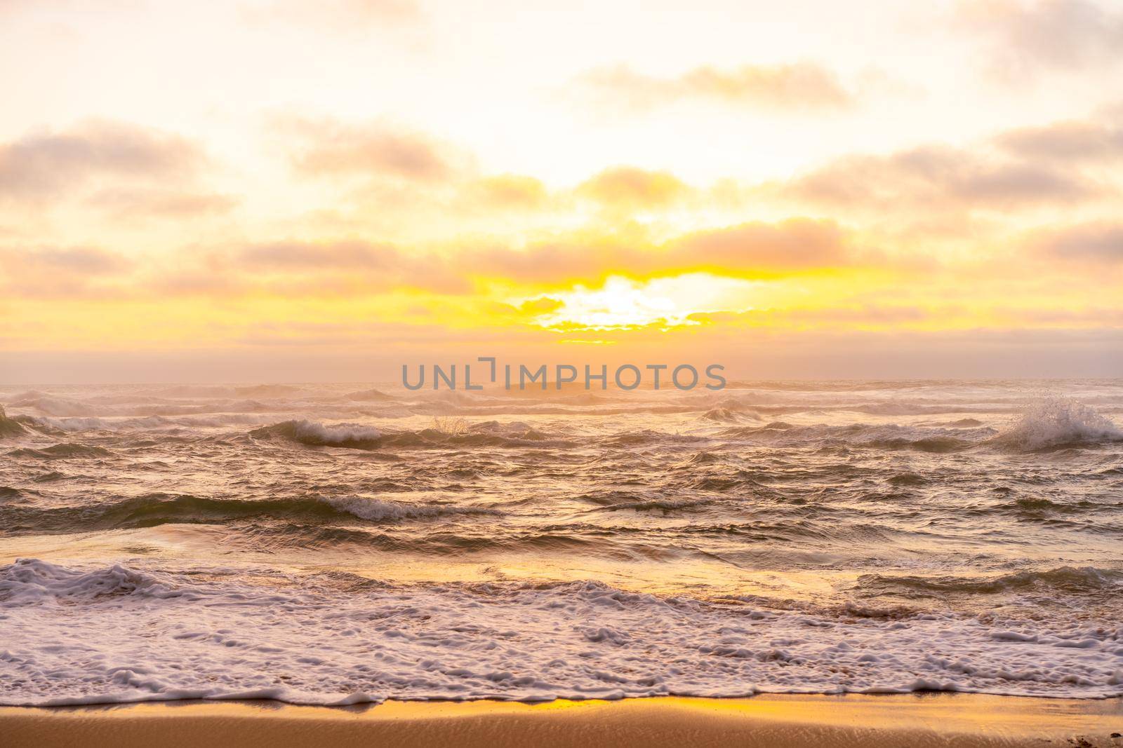 Landscape with sea sunset on beach. Beautiful view on ocean horizon with orange sun and clouds, dramatic mood