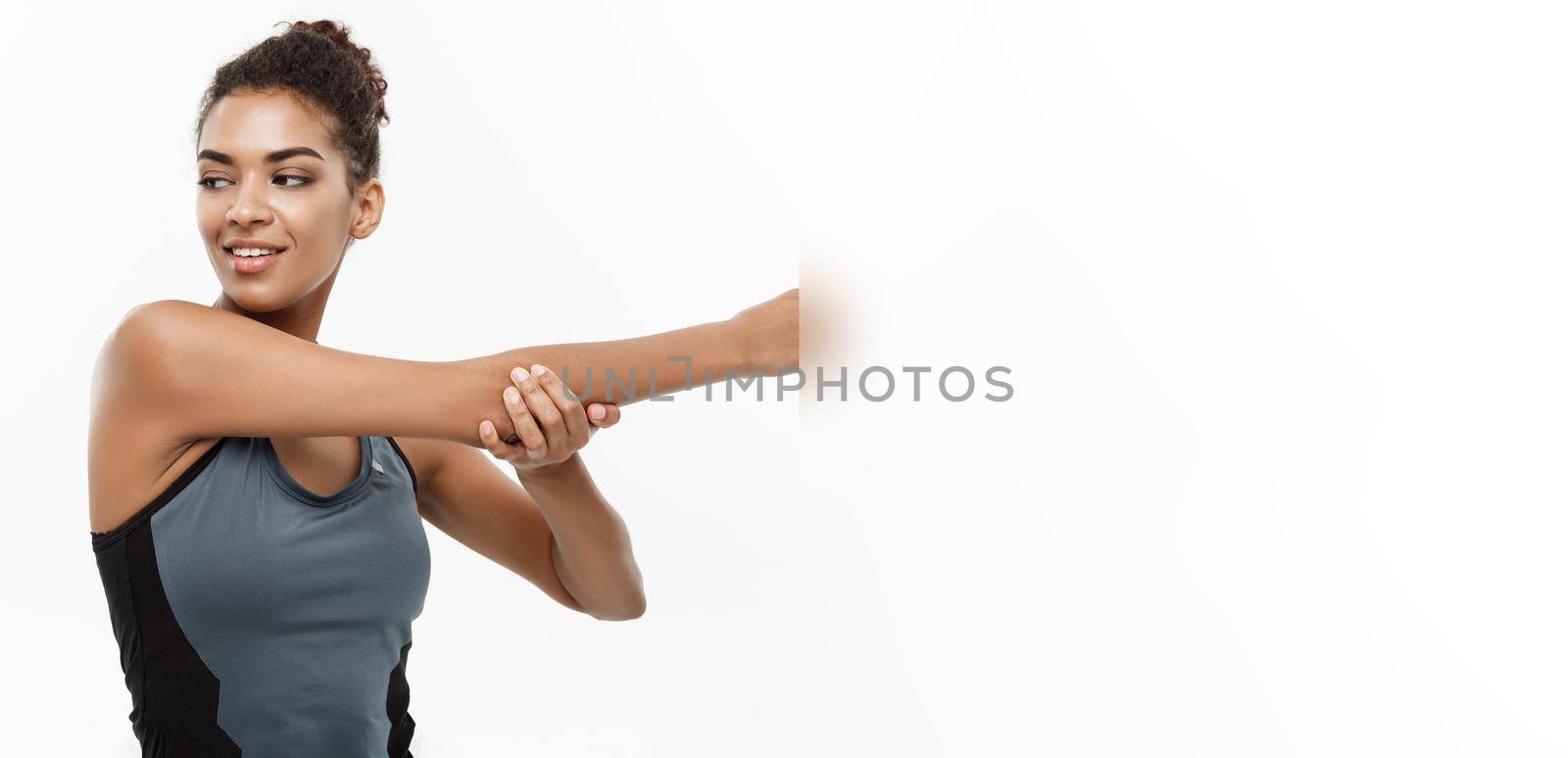 Sport, training, lifestyle and Fitness concept - portrait of beautiful happy African American woman stretching hands. Isolated on white studio background